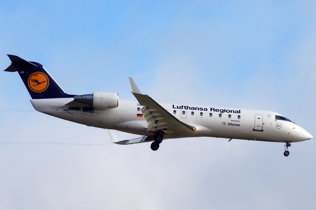 A Lufthansa Bombardier CRJ-100 flying in the sky. 