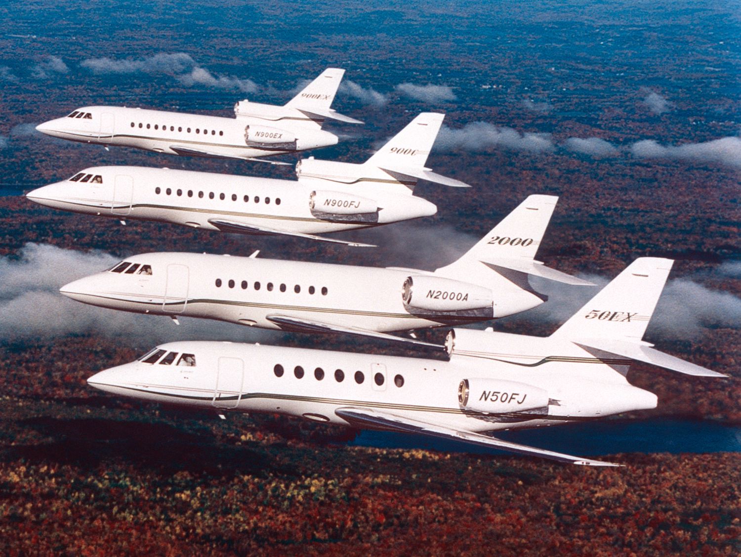 Four Dassault Falcon jets flying in formation.
