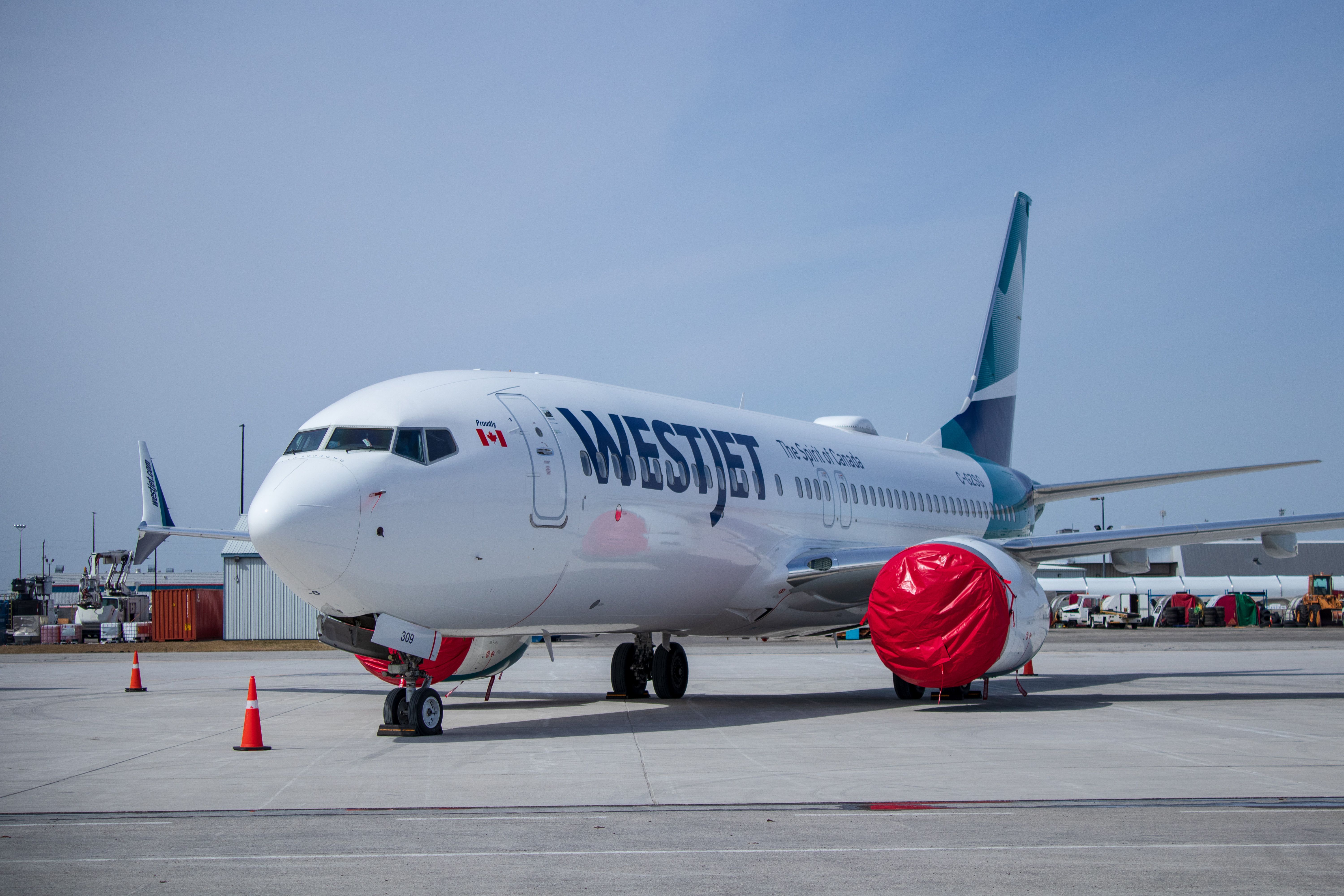 APRIL 4, 2019: Grounded WestJet 737 MAX8 sits on the ramp at John C. Munro Hamilton International Airport (YHM) with engines covered.
