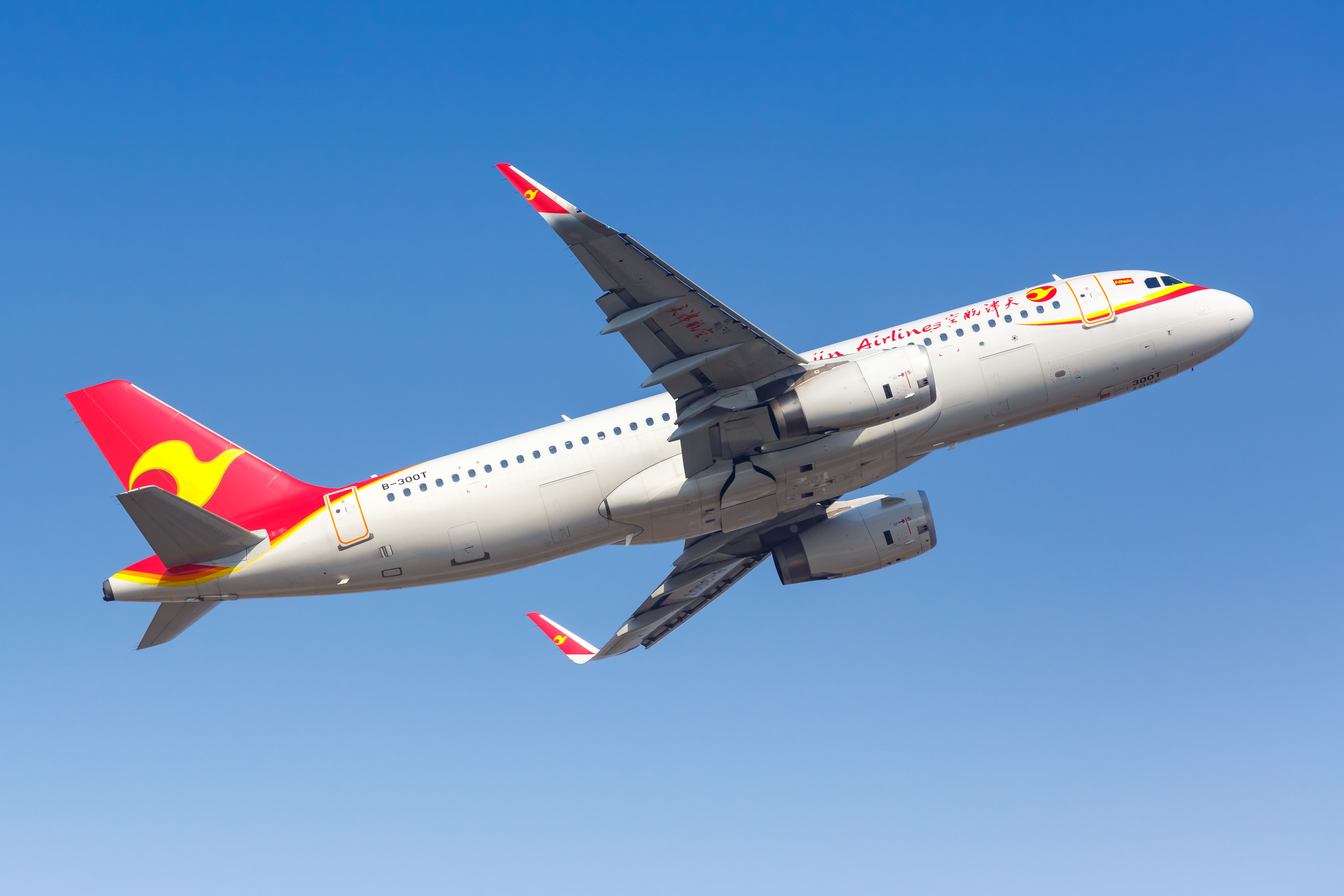 A Tianjin Airlines Airbus A320 flying in the sky.