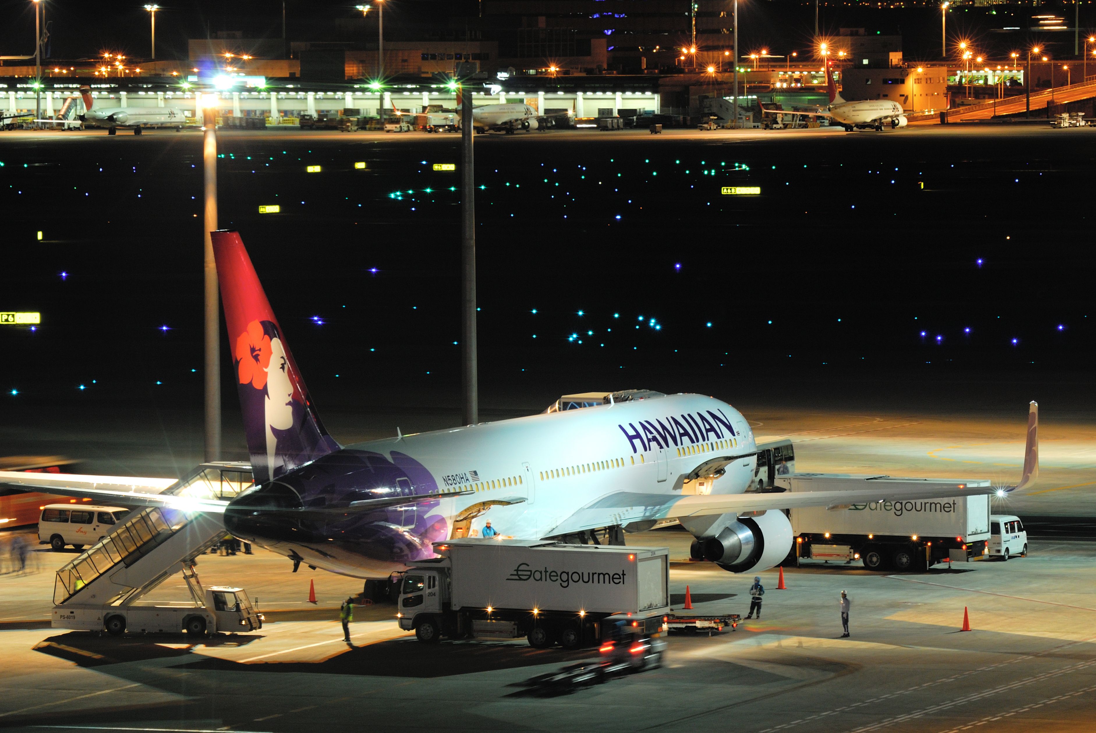 A Hawaiian Airlines Boeing 767 being loaded at an airport. 