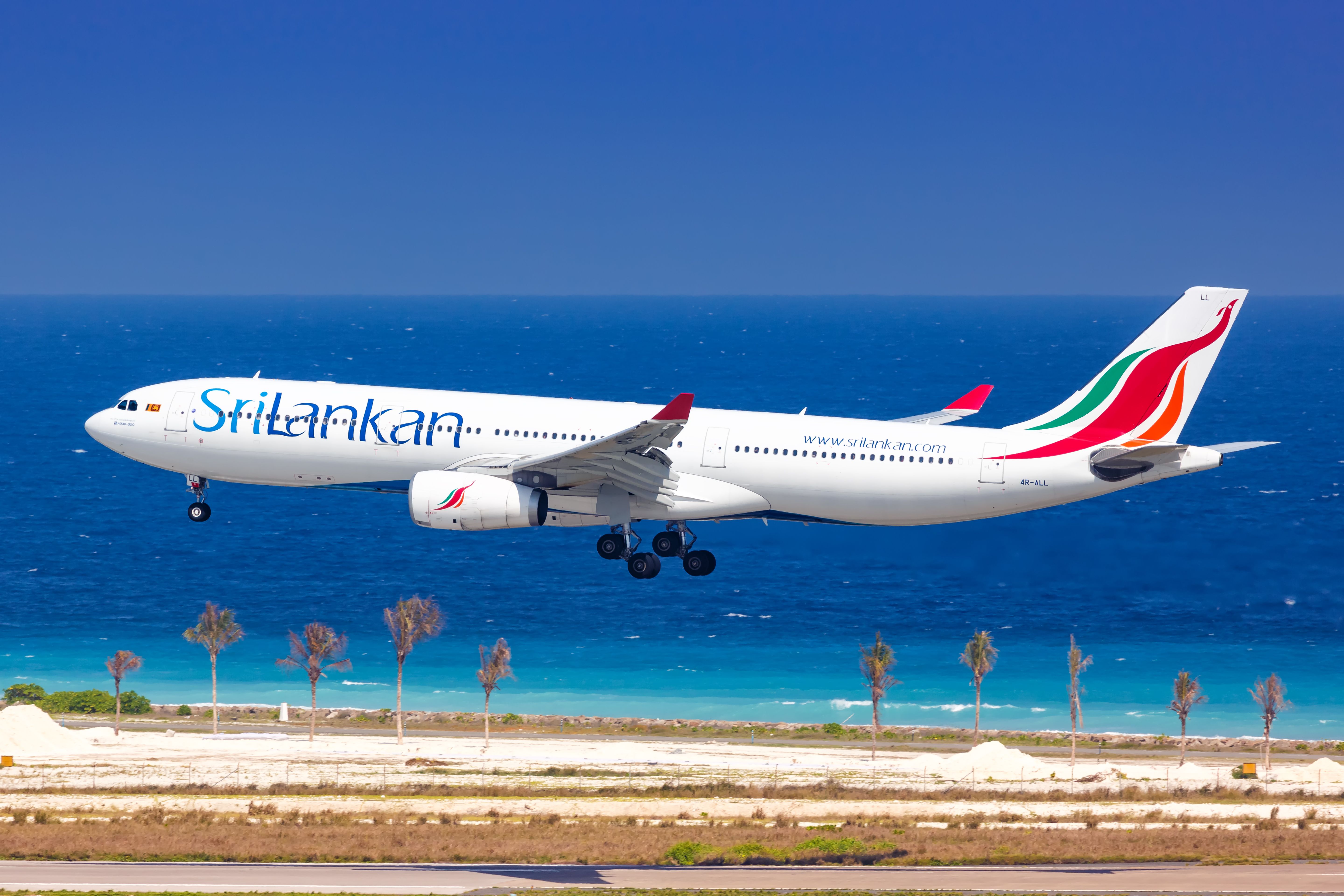 A SriLankan Airlines Airbus A330 about to land at an airport near a beach. 