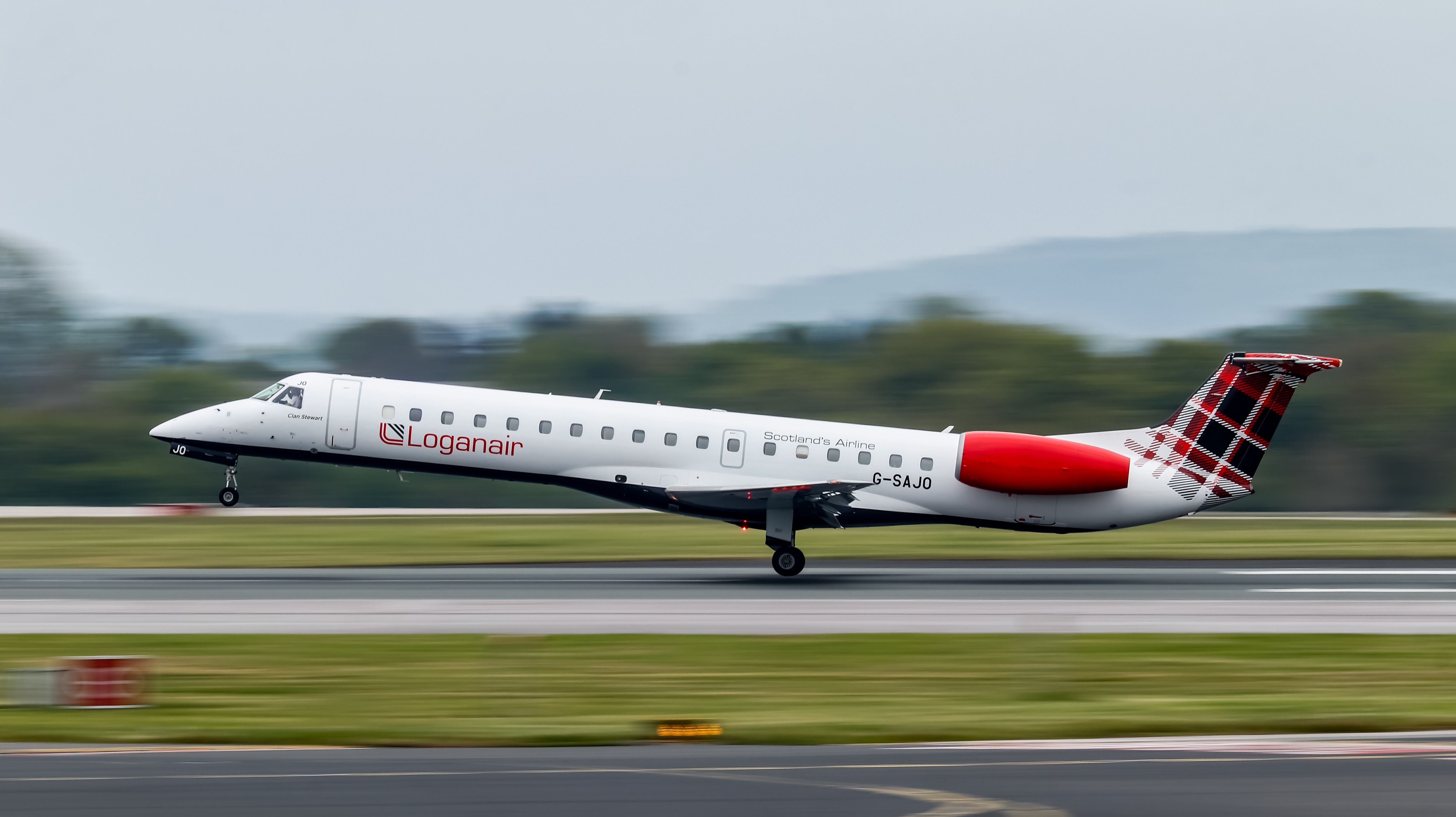 A Loganair Embraer ERJ jet mid rotation on the runway. 