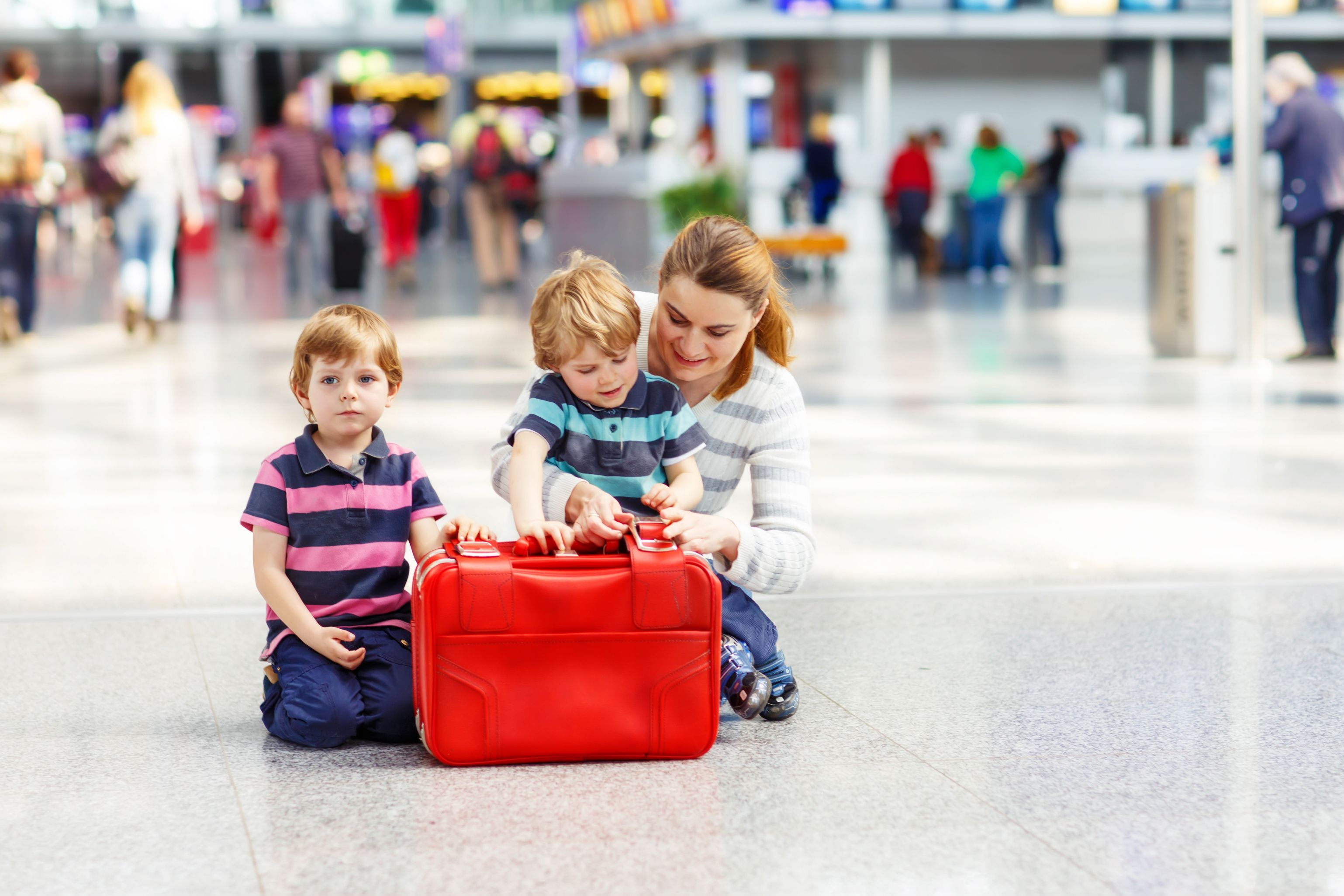 A mother with two children in an airport terminal.