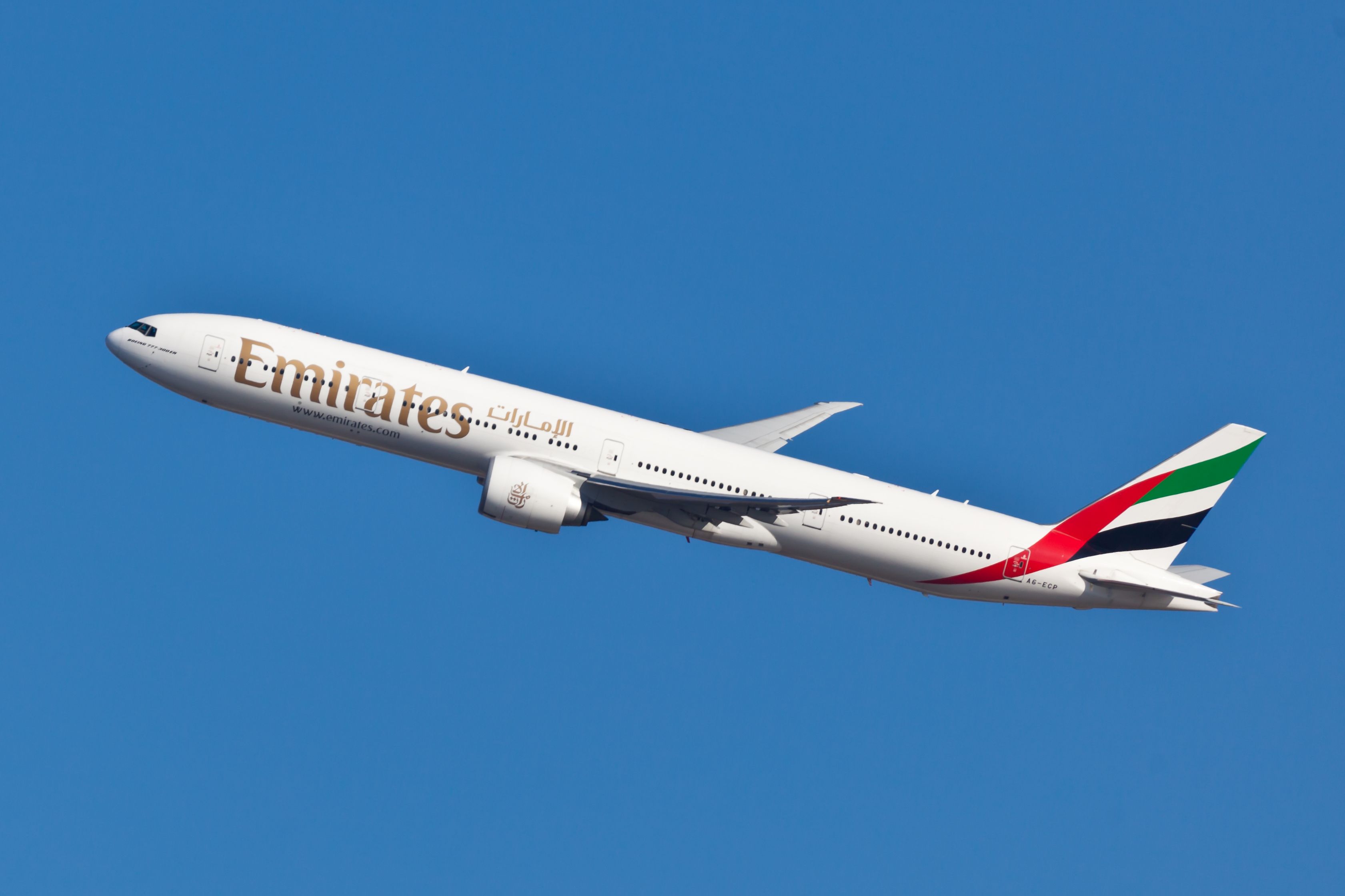 An Emirates Boeing 777 flying in the sky.