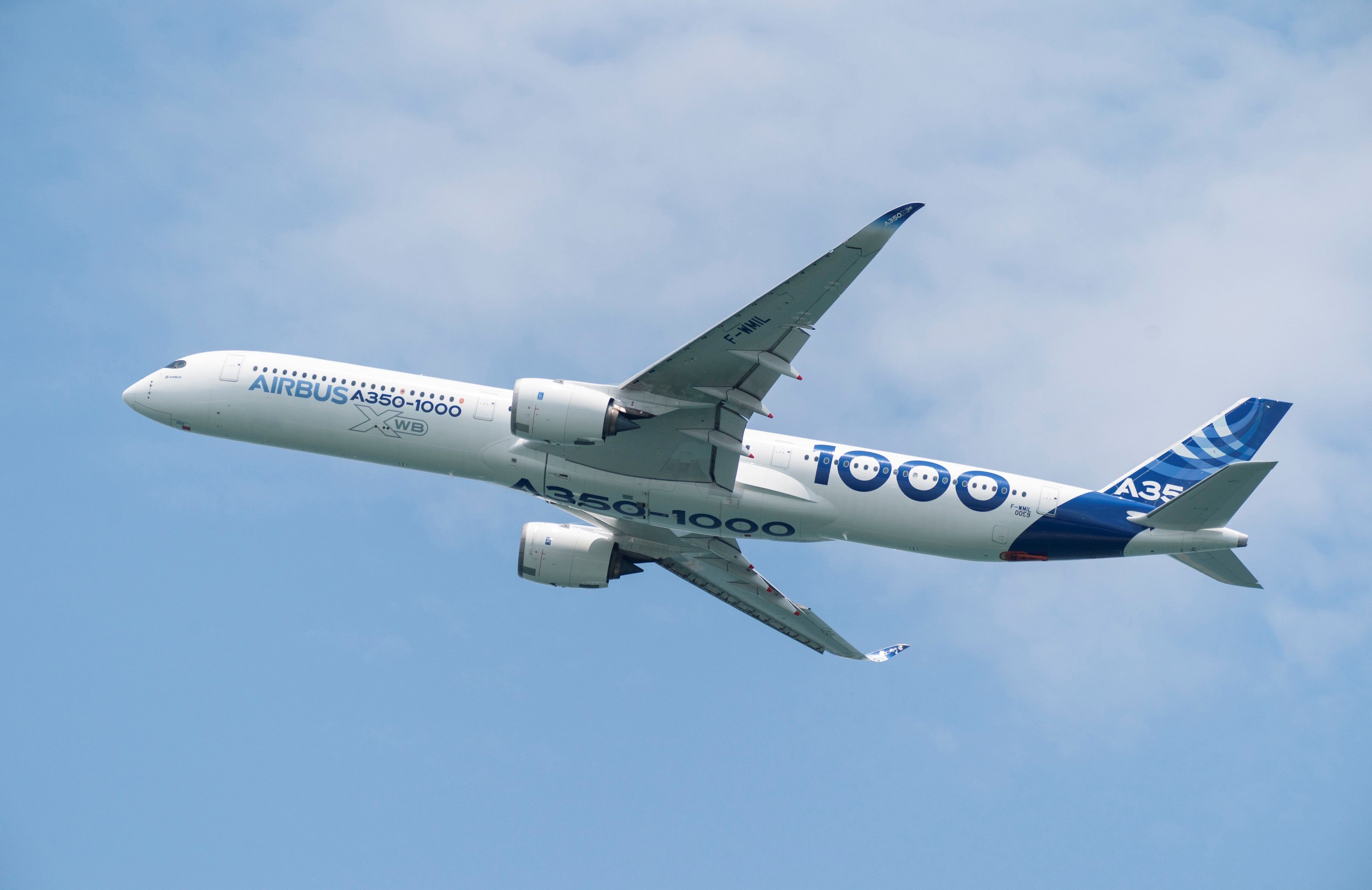 An Airbus A350-1000 in house livery flying in the sky. 