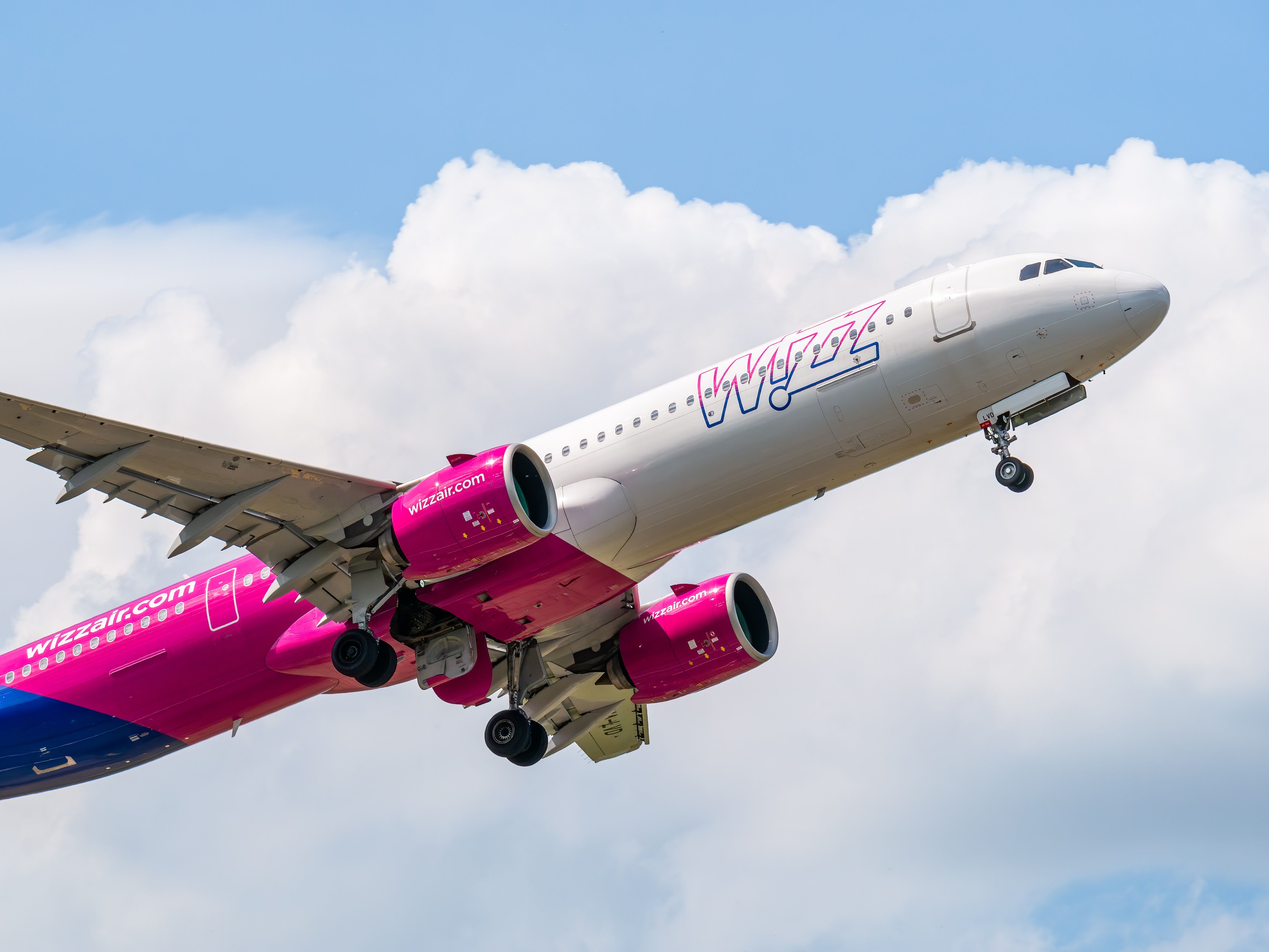 A Wizz Air A321neo flying in the sky.