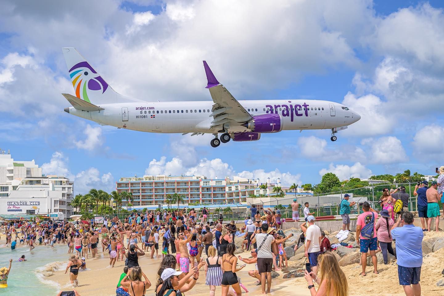 An Arajet Boeing 737 MAX 8 just above many beach goers in St. Martin.