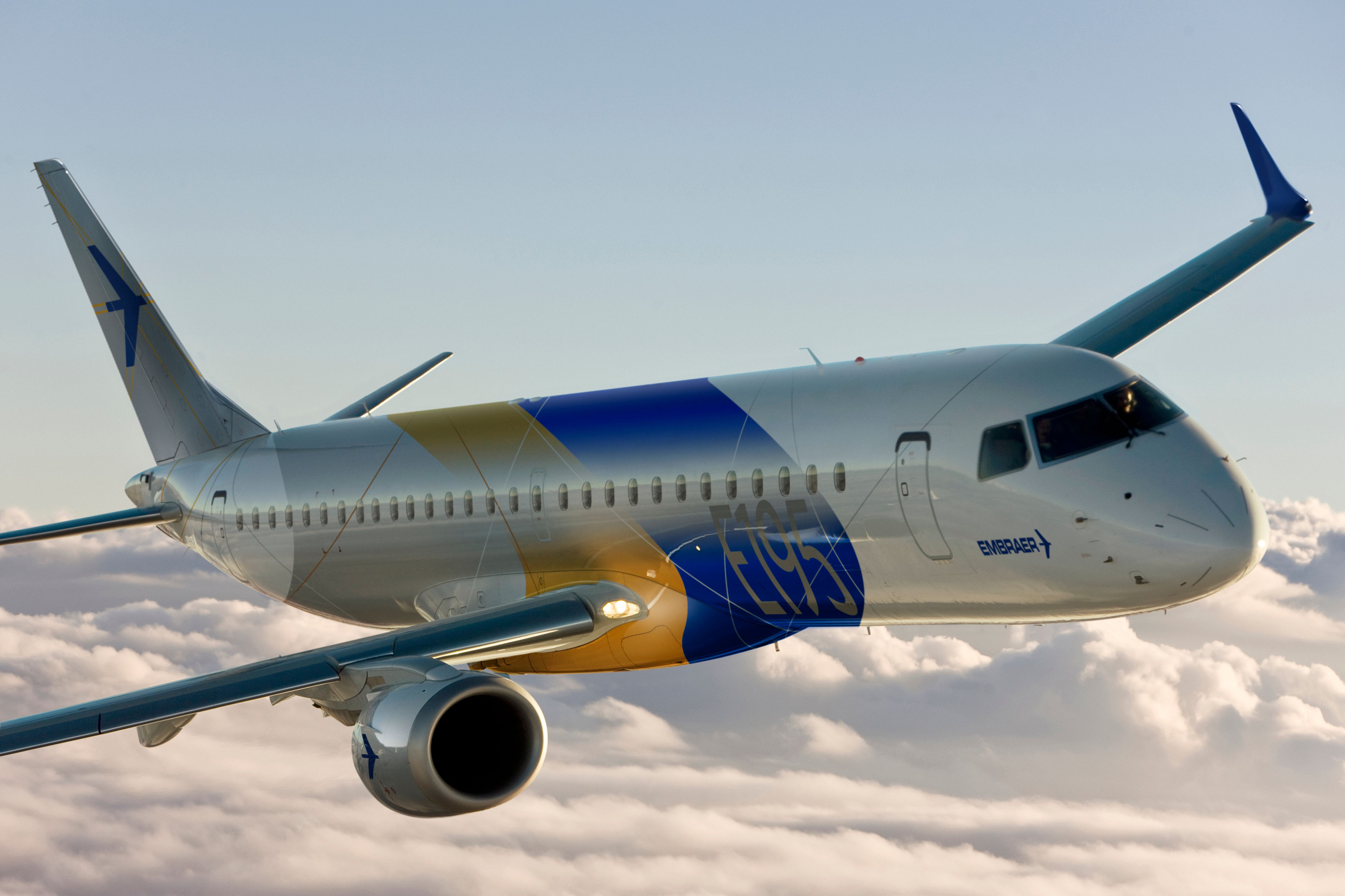 An Embraer E-195 flying above the clouds.