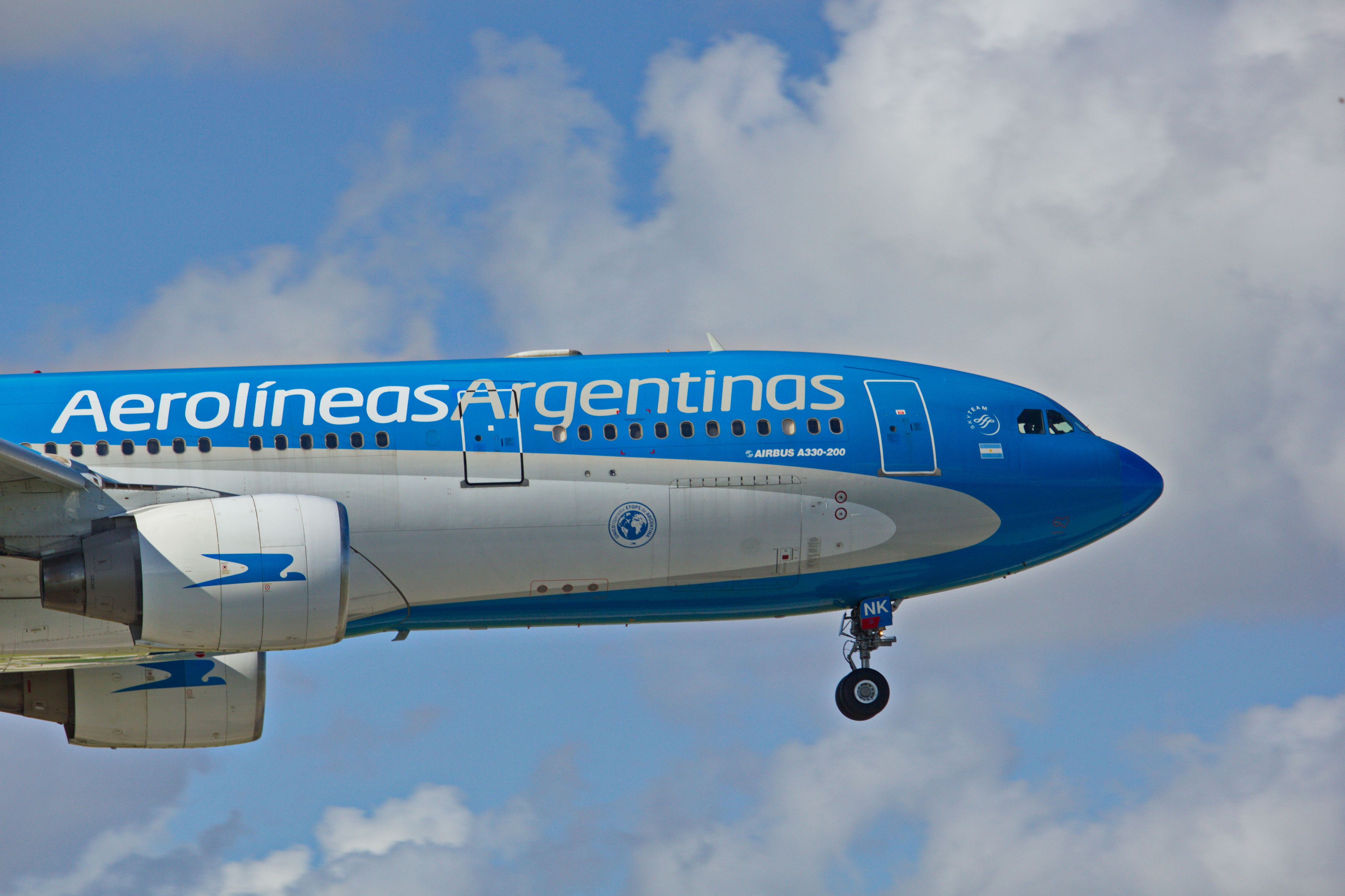 A closeup of An Aerolineas Argentinas Airbus 330 flying in the sky.