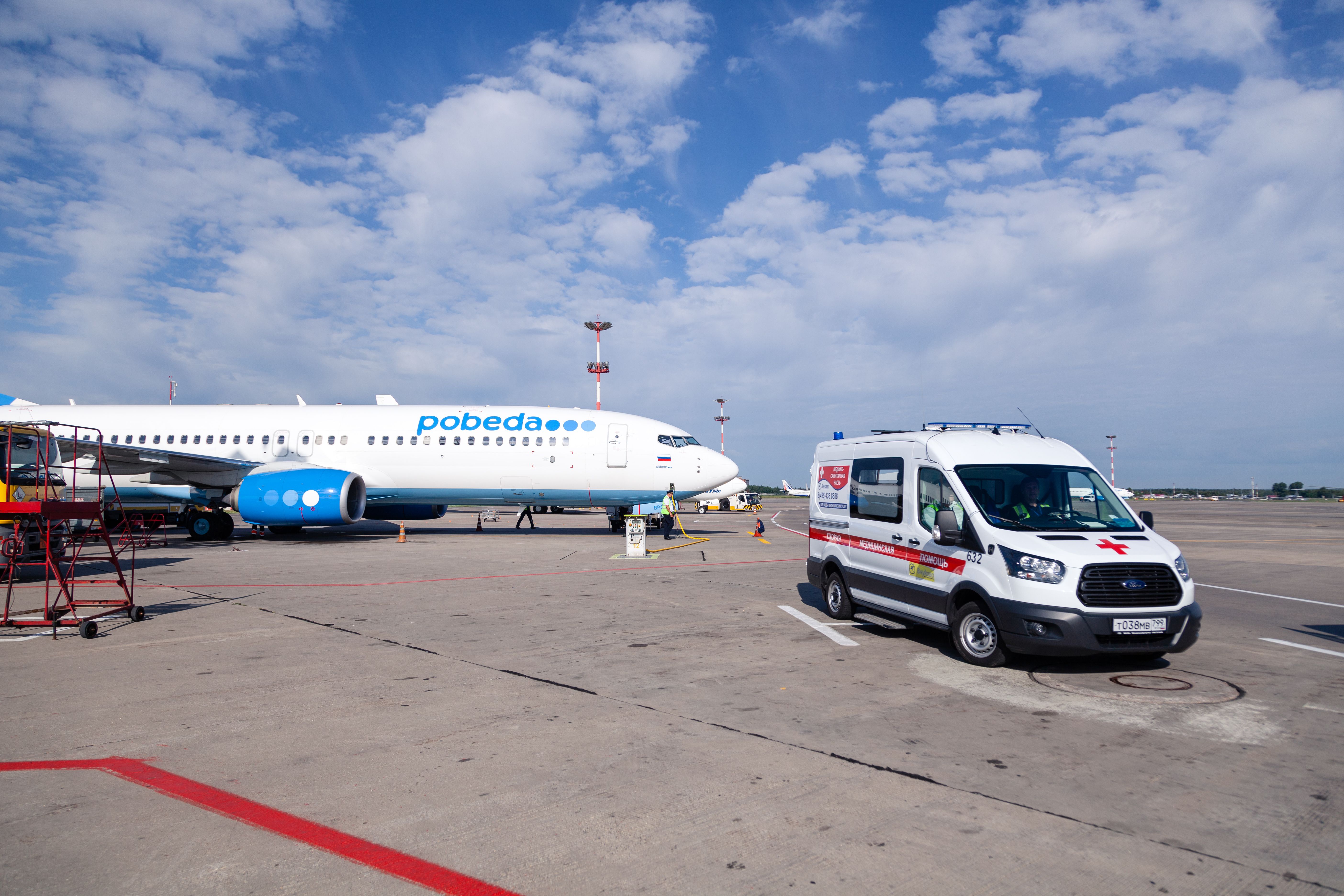 An ambulance in front of a Pobeda aircraft 