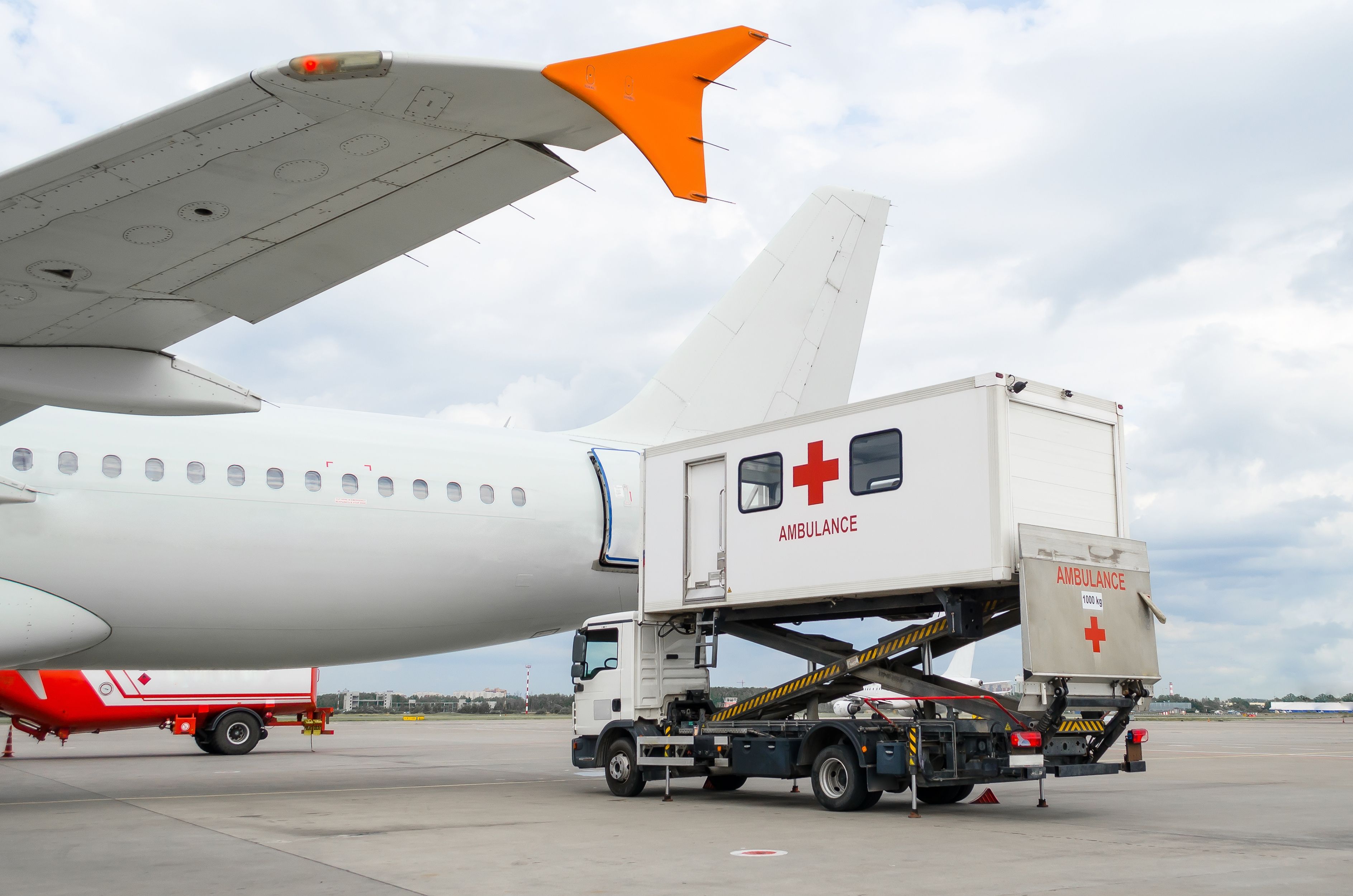 An ambulance in front of an aircraft 