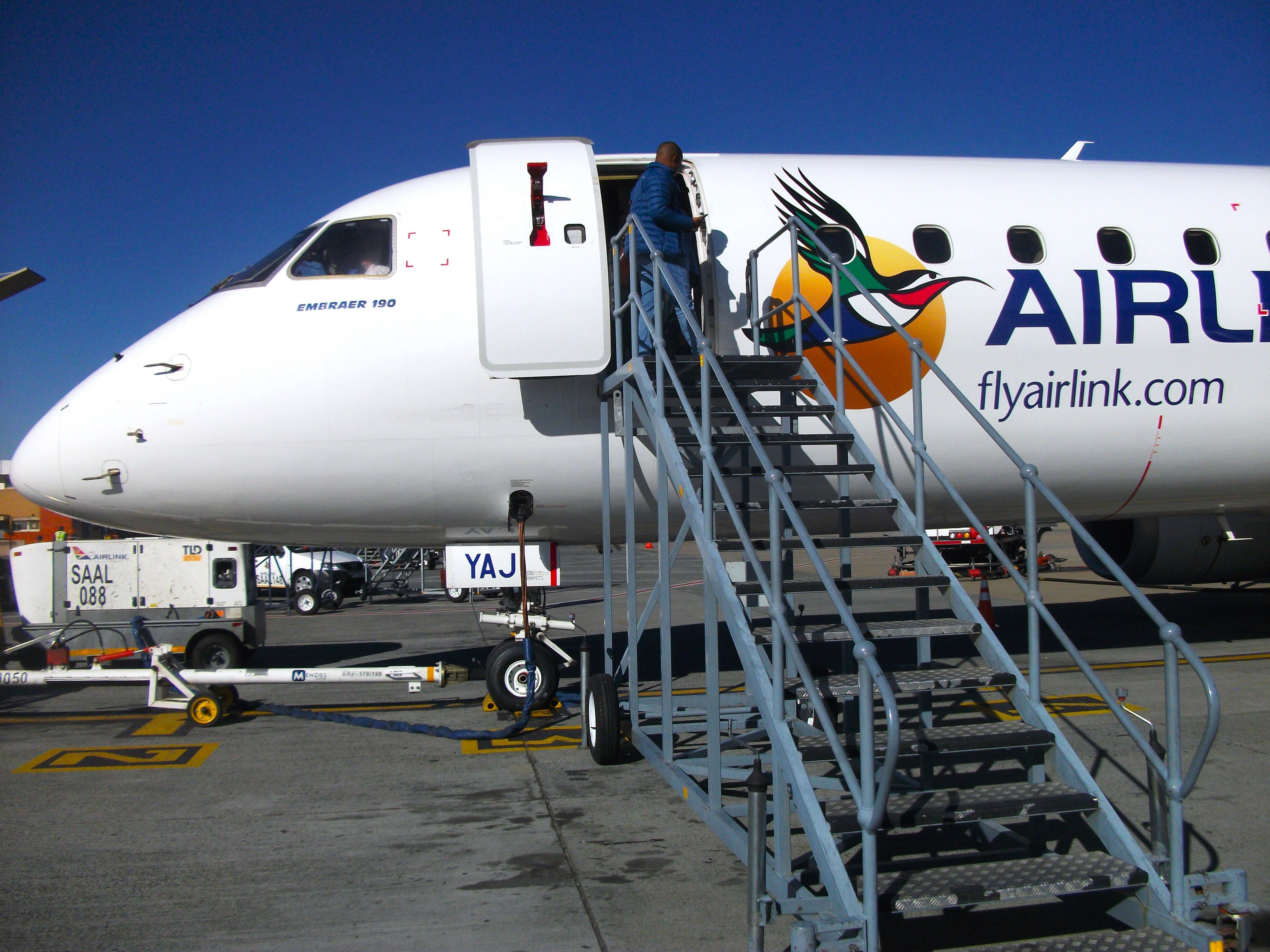 A closeup of an Airlink Embraer 190 on an airport apron.
