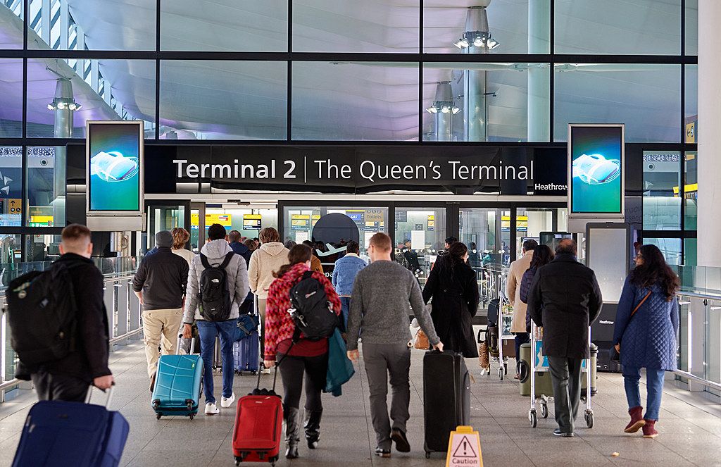 Travelers with lots of luggage enter Terminal 2 at London Heathrow Airport.