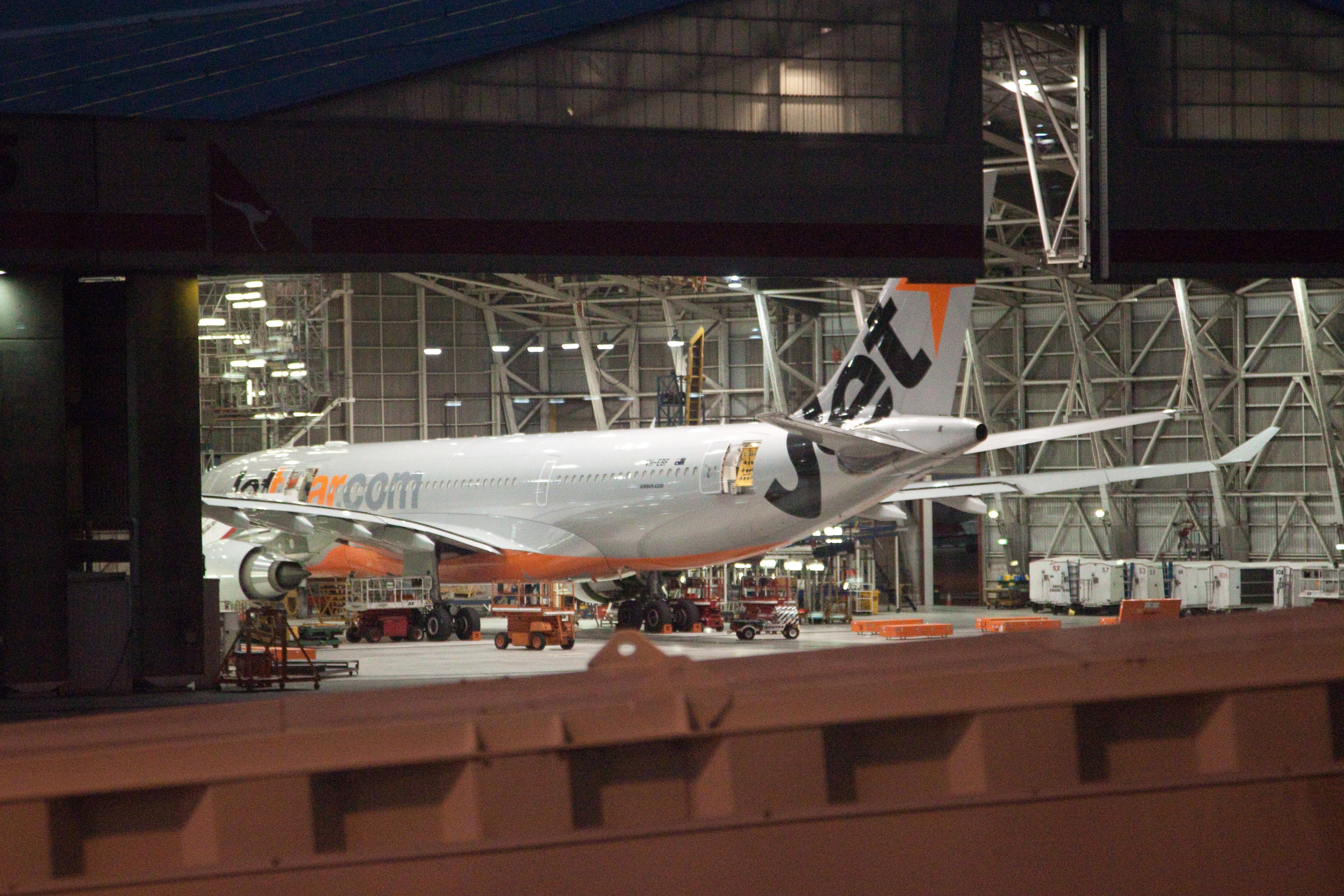 A Jetstar Airbus A330 undergoing maintenance in a hangar at Sydney Airport.