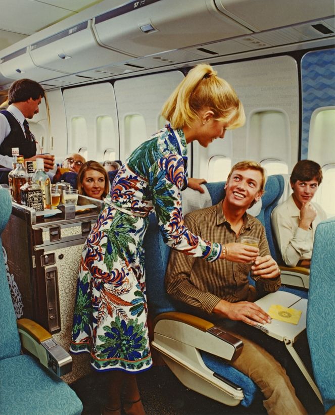 Flight attendants serving passengers in the Qantas business class cabin in the 1970s .