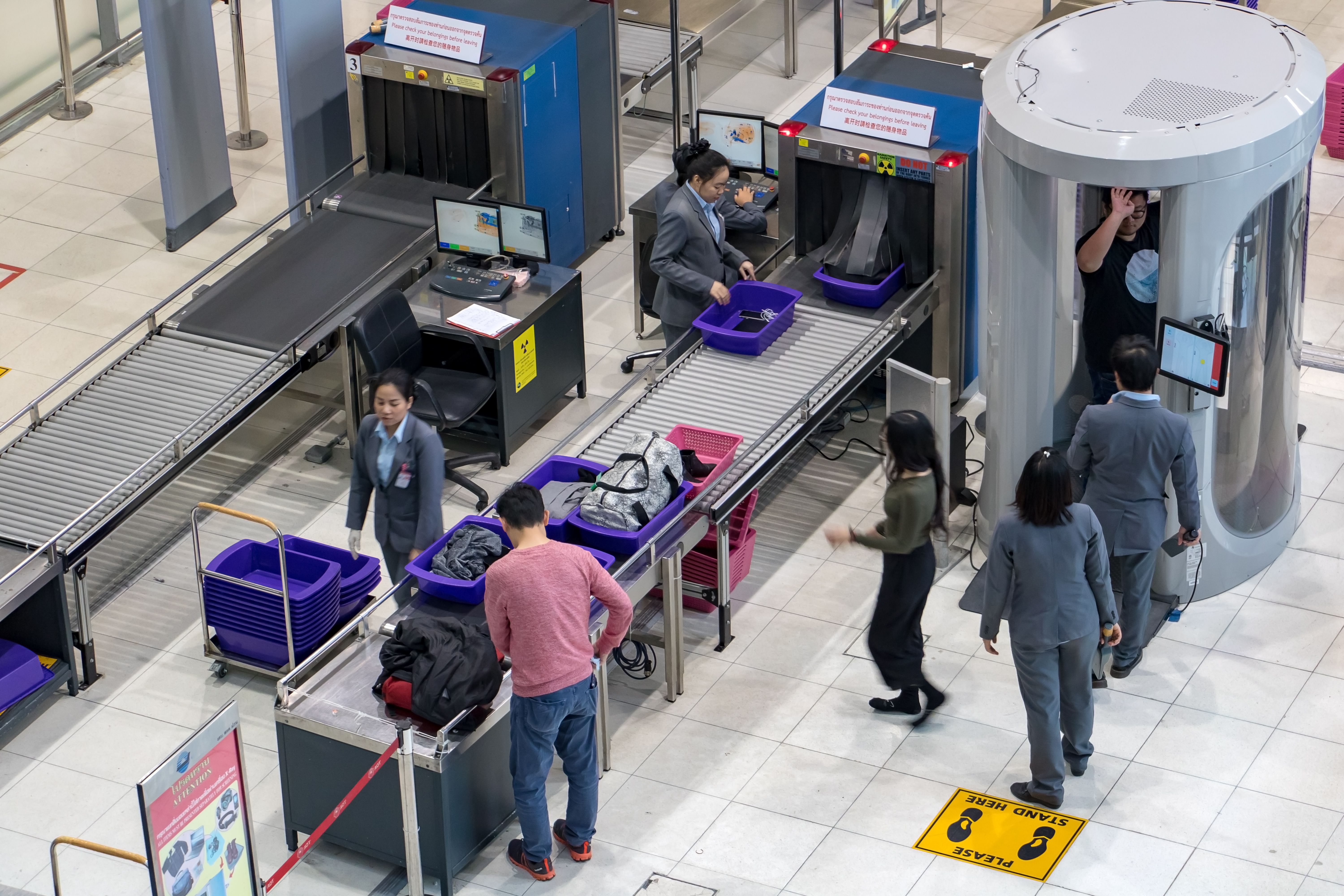 A passenger is scanned using a full body scanner at the Bangkok airport in Thailand.