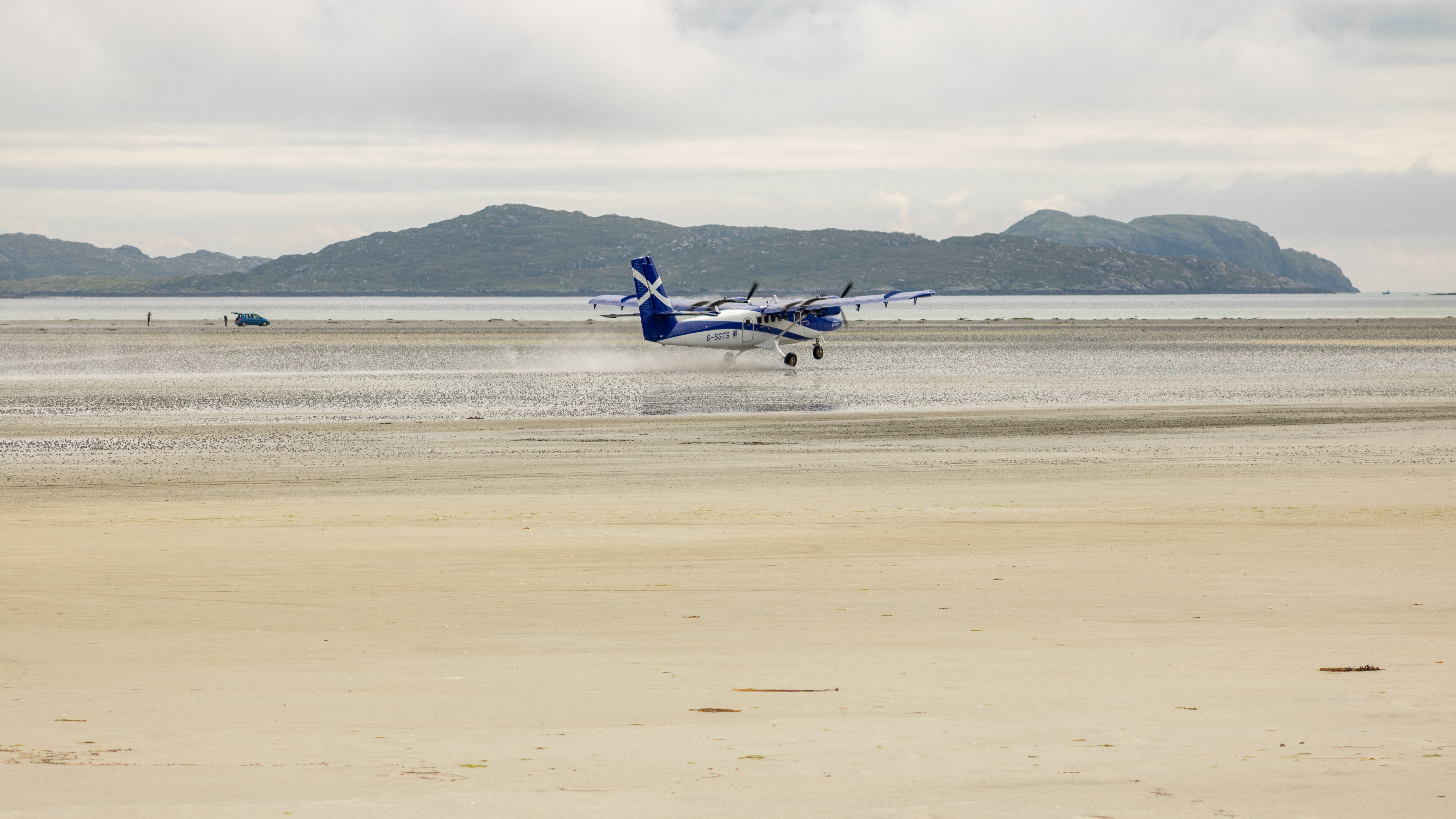 The Loganair Twin Otter aircraft landing and taking off at Barra Airport, Outer Hebrides, Scotland