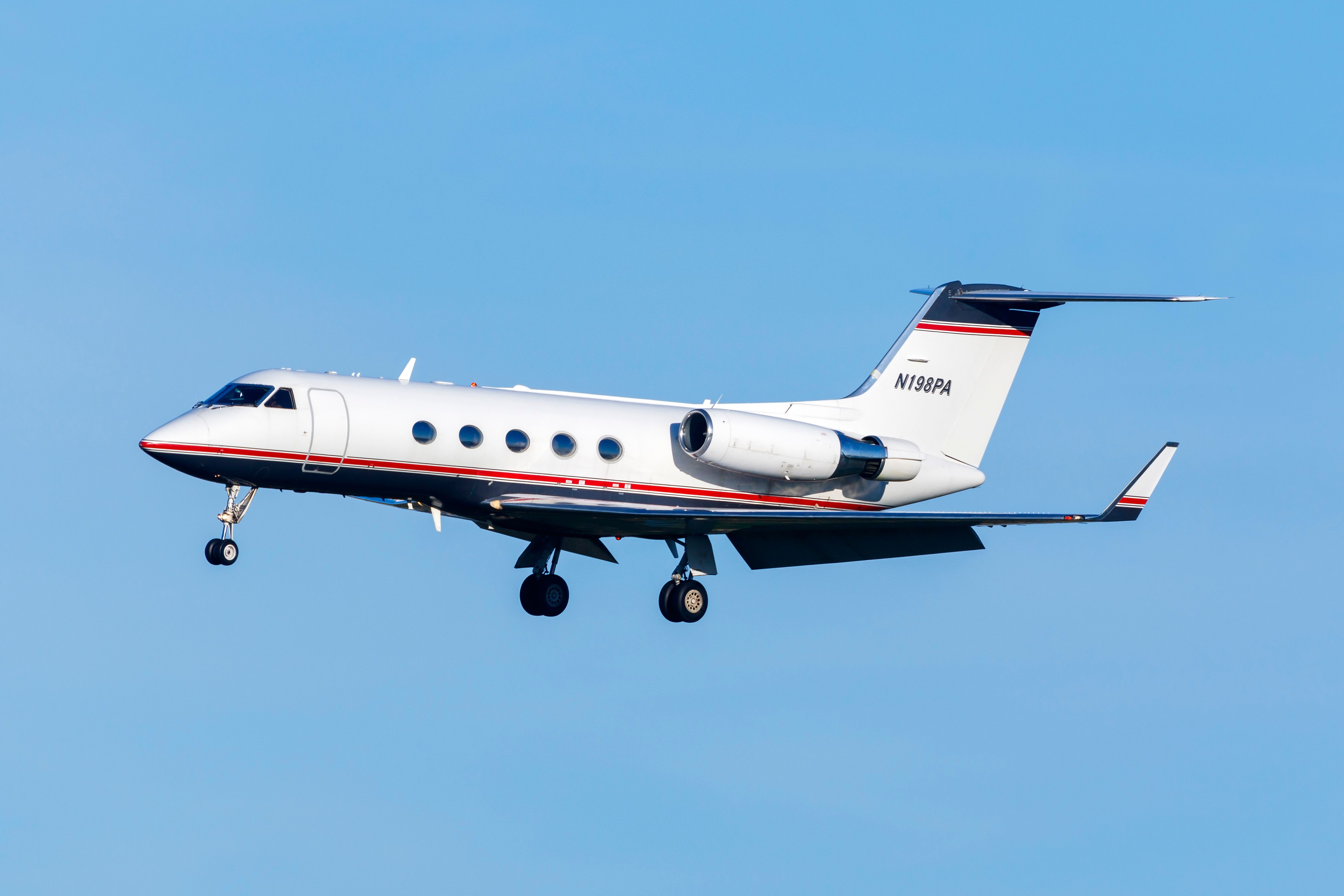 A Gulfstream G-III business jet flying in the sky.