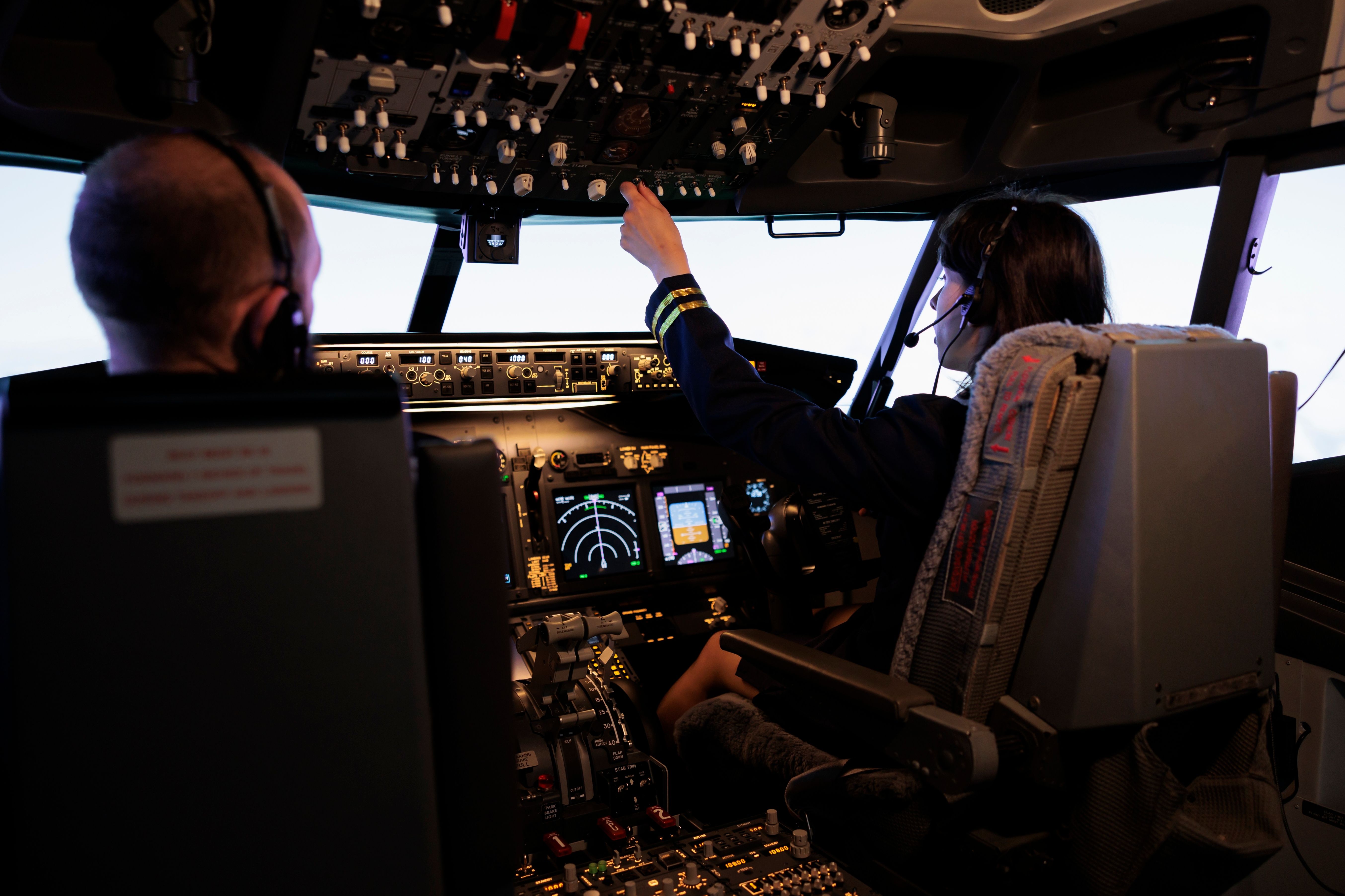 Woman piloting an aircraft simulator with a male co-pilot