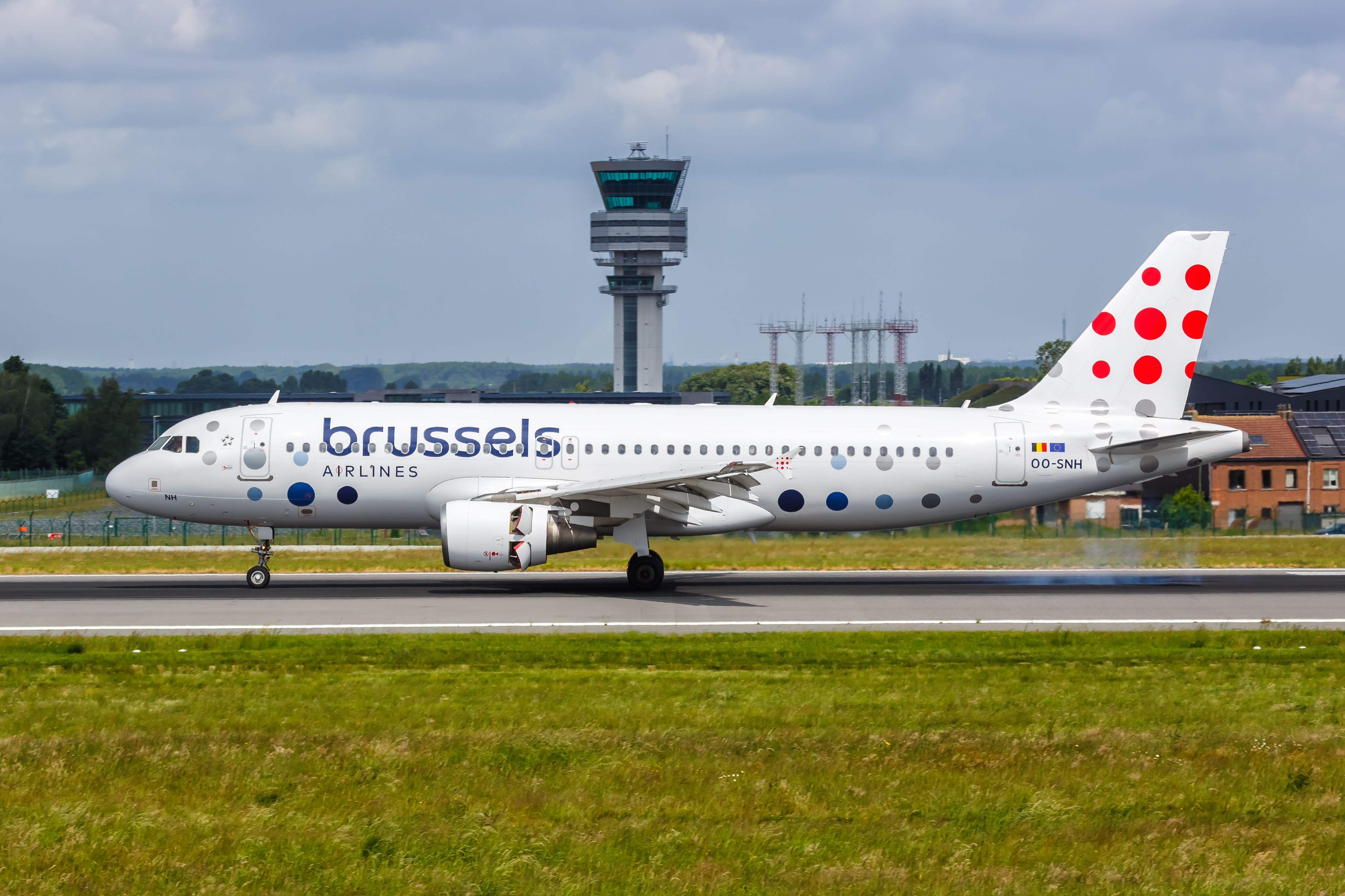 brussels airbus a320 on ground with control tower behind