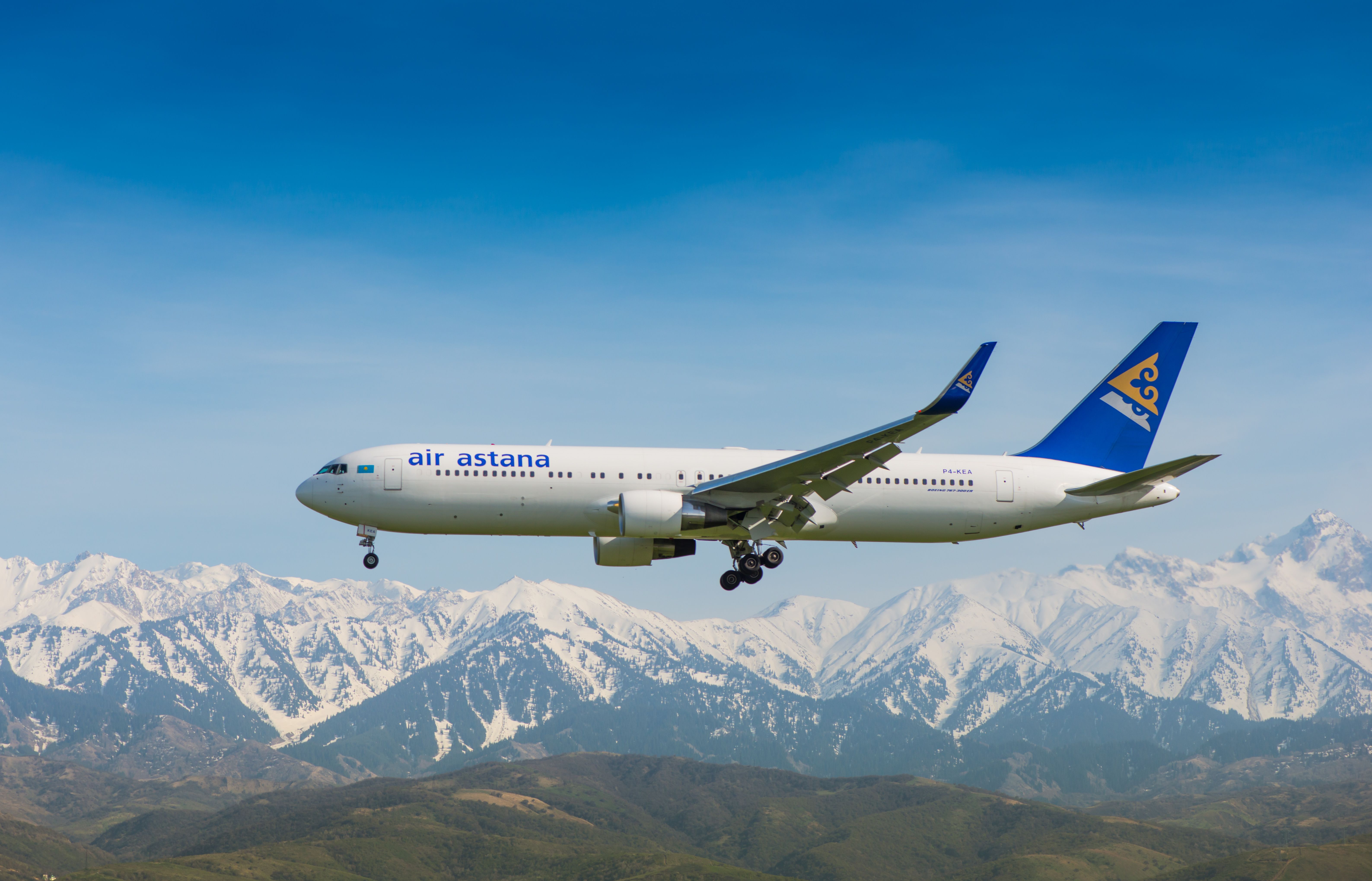 An Air Astana Boeing 767 is pictured flying past the mountains near Almaty, a city in the south of Kazakhstan.