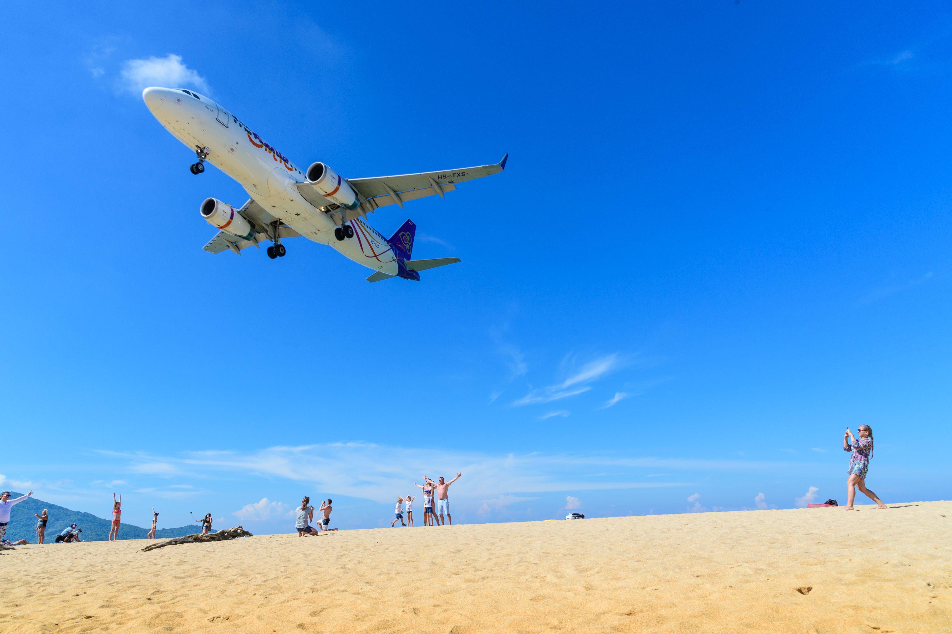 An airplane landing above the beach near (Phuket) International Airport