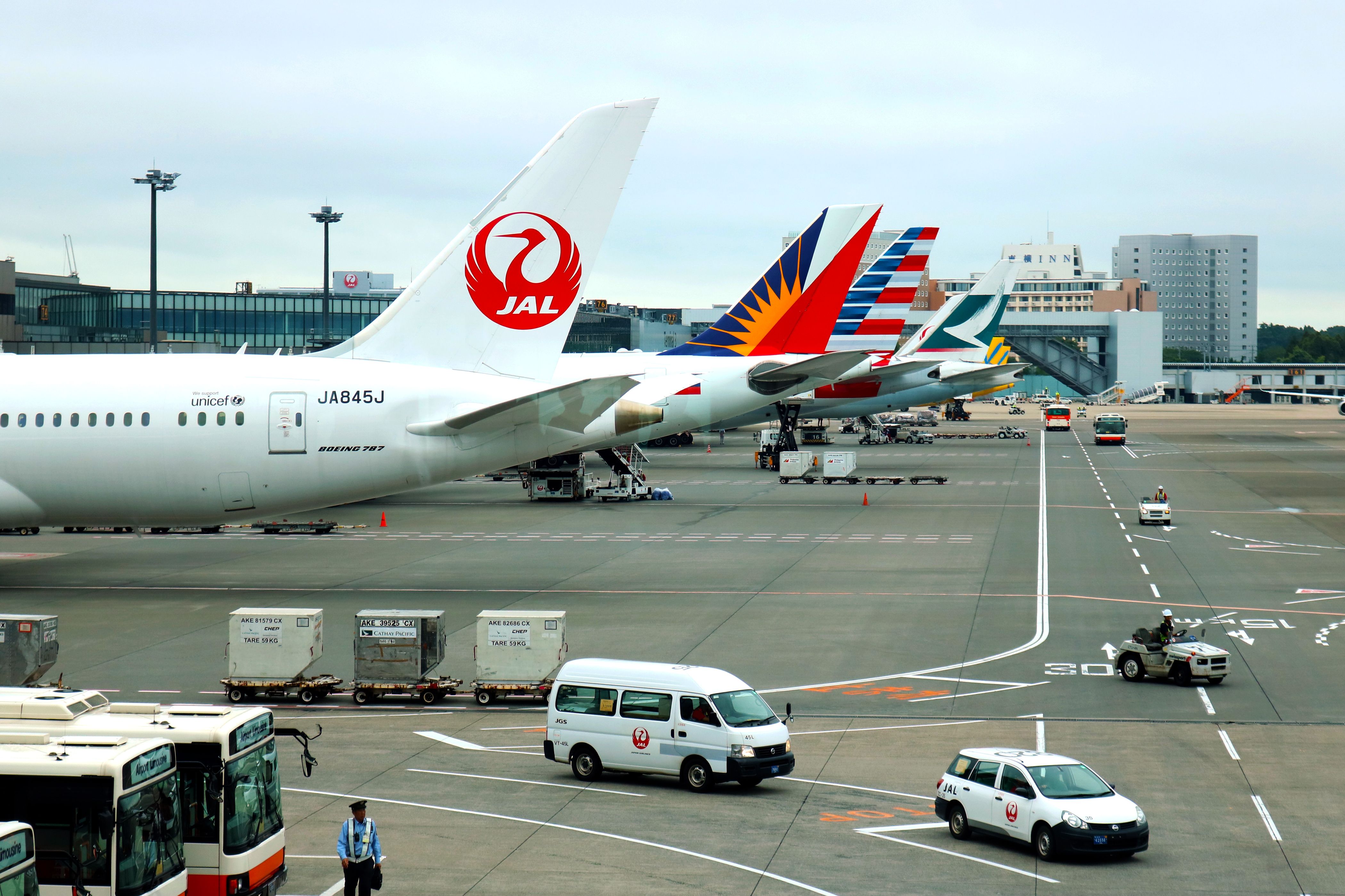 Multiple widebody jets parked at Tokyo Narita Int'l Airport.