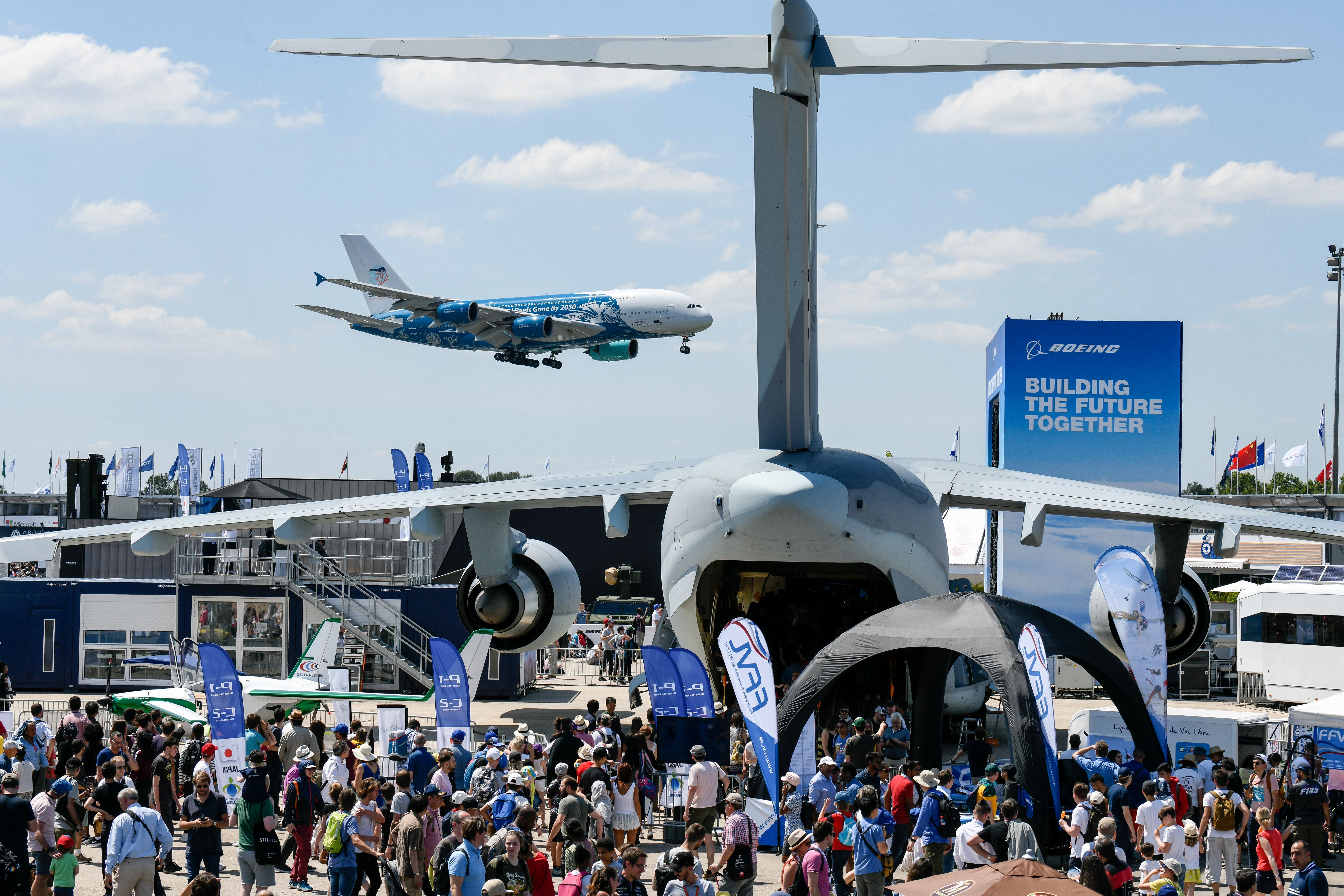 A photo shows crowds at the 2019 Paris Air Show watching the Airbus A380 flying past the Airbus A400M