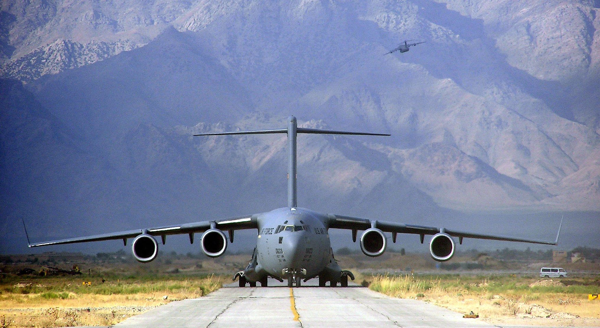 A large military transport aircraft on  a runway.