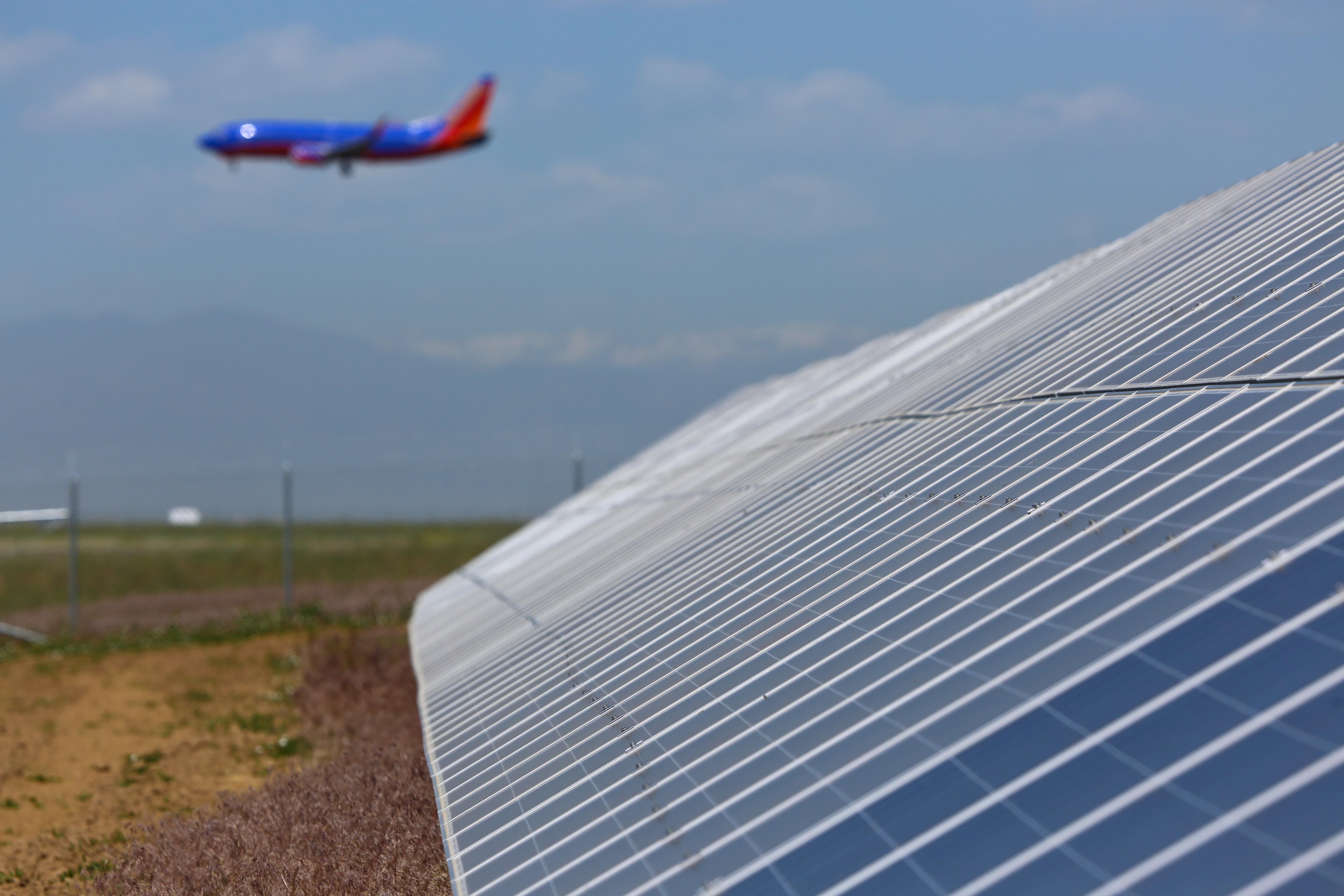Solar panels and a Southwest aircraft overhead at Denver International Airport.