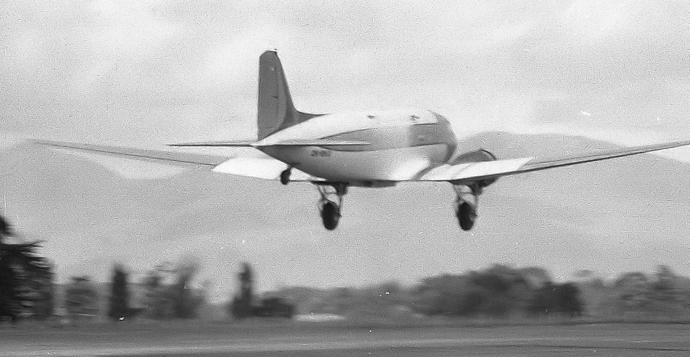 A black and white photo of a DC-3 about to land.