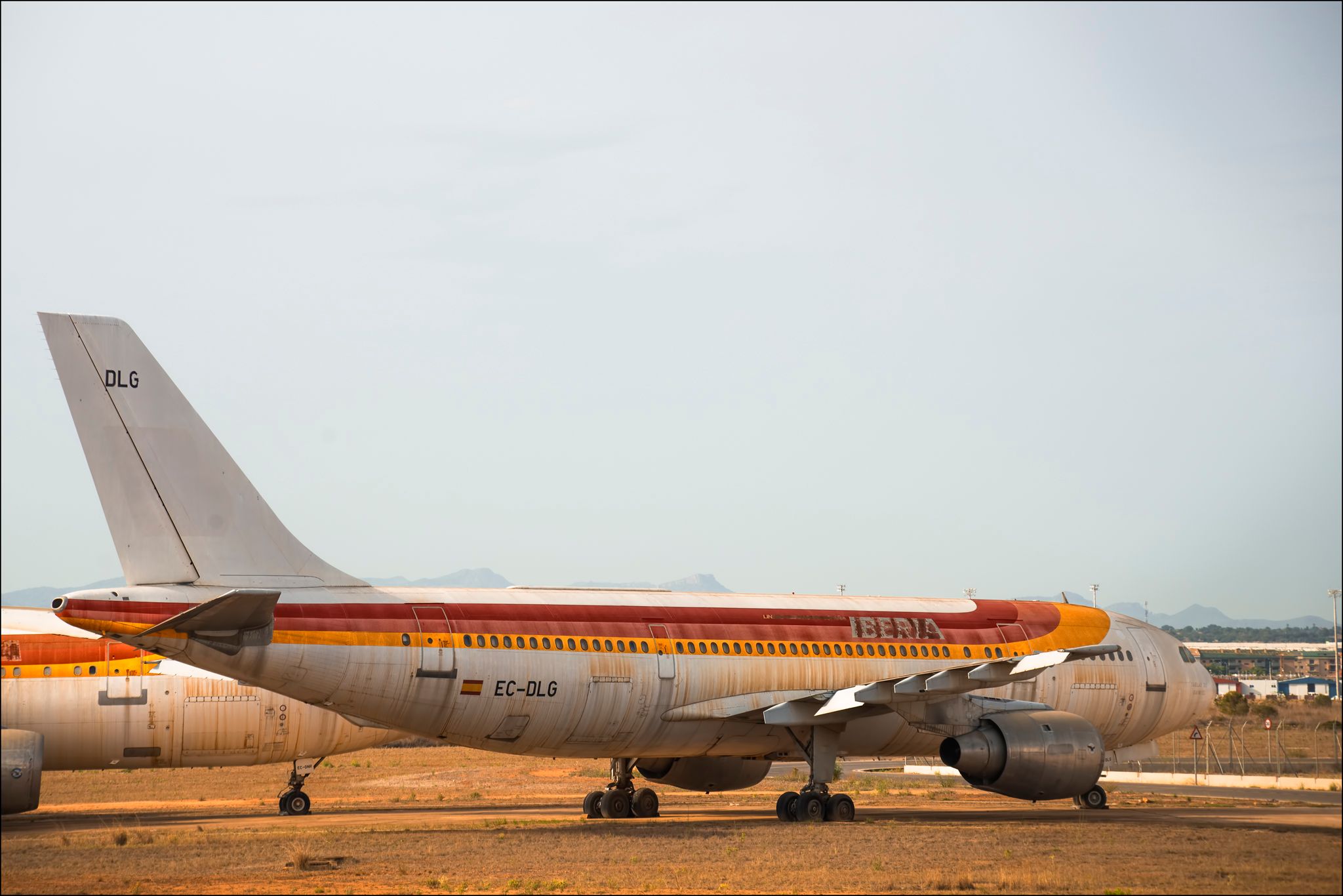 An old Iberia Airbus A300 parked at an airfield.
