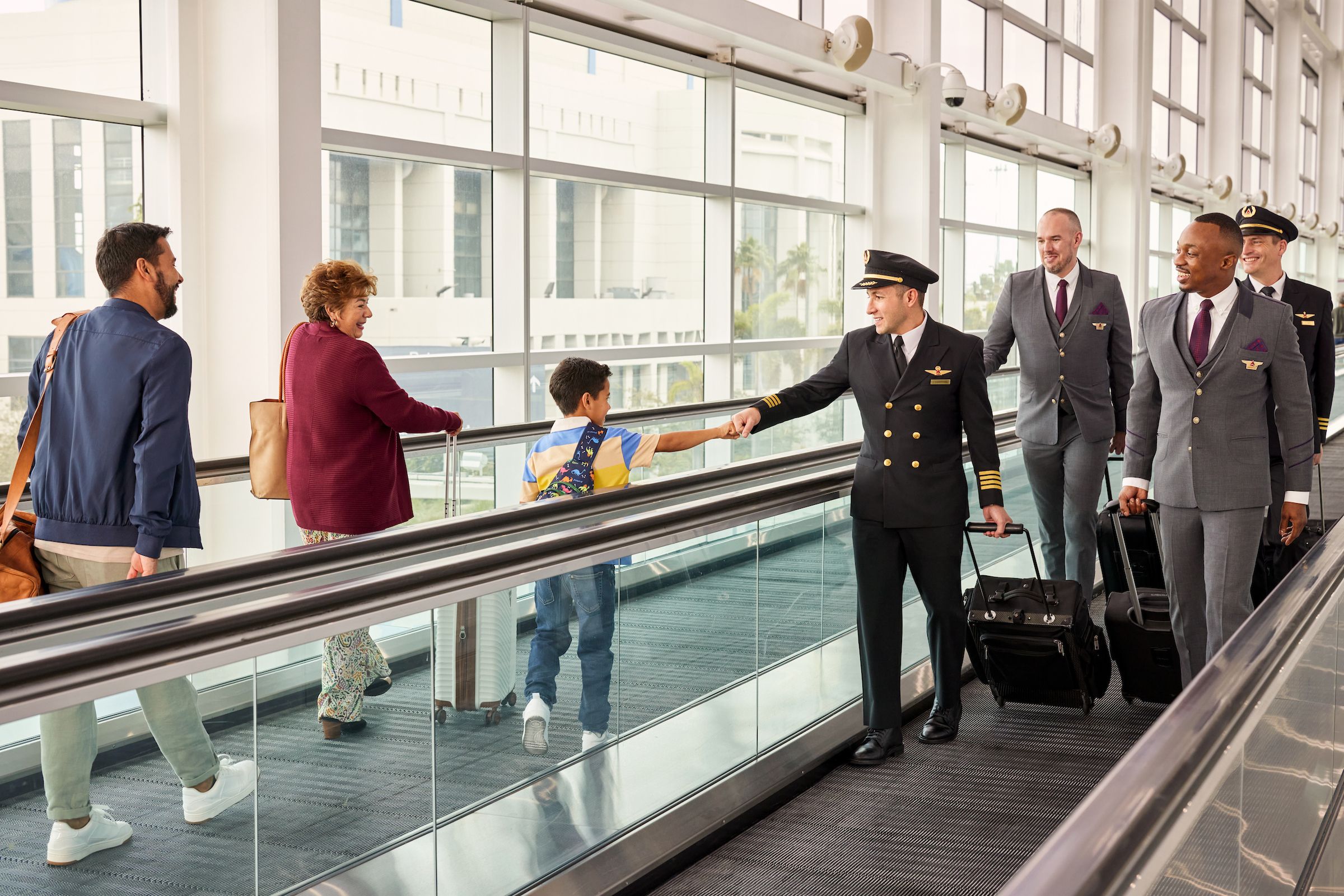 An airline captain greets a young traveller. 