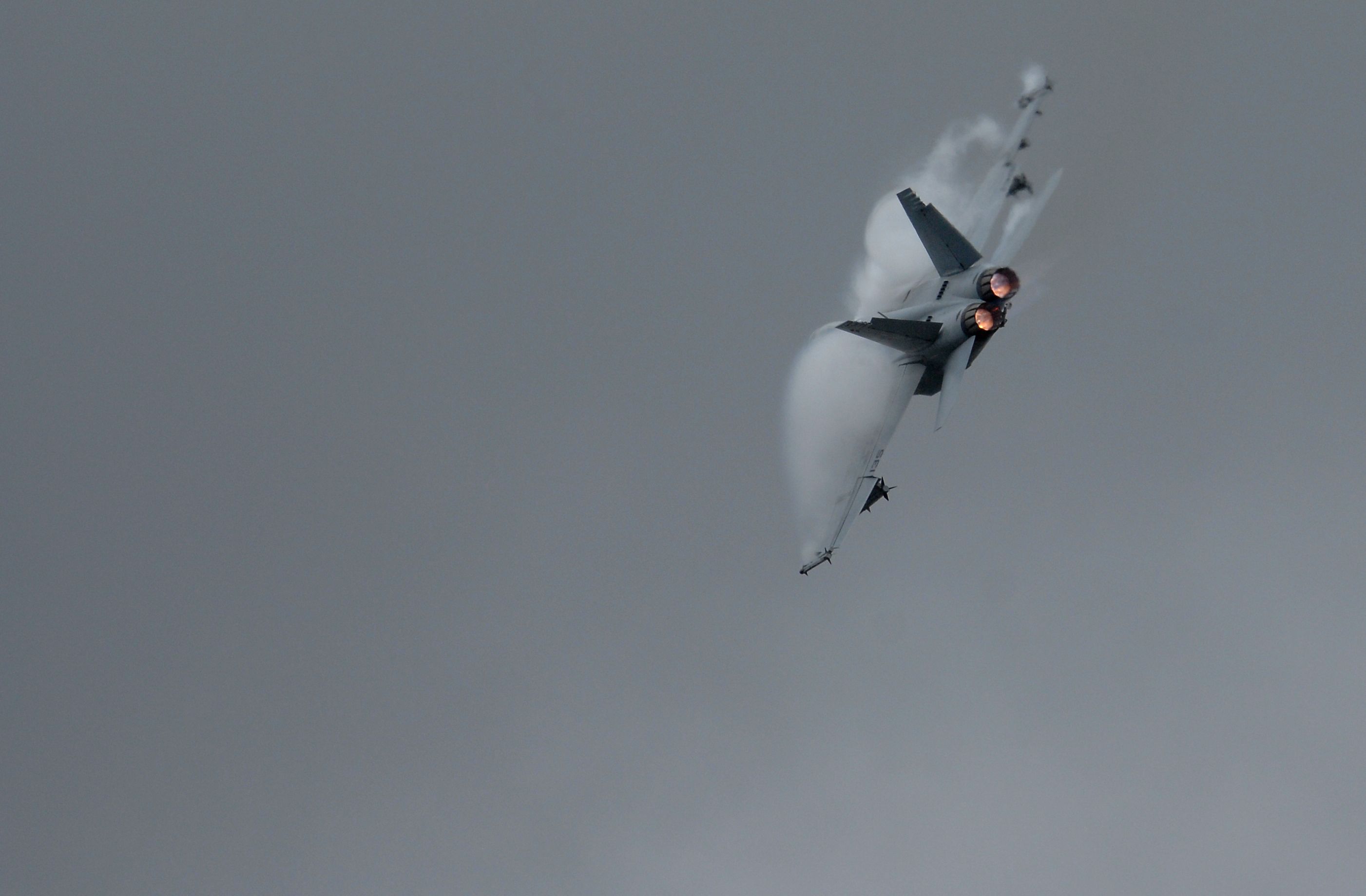 A U.S. Navy F/A-18F Super Hornet punches through the clouds above thousands of spectators during the Farnborough International Air Show.