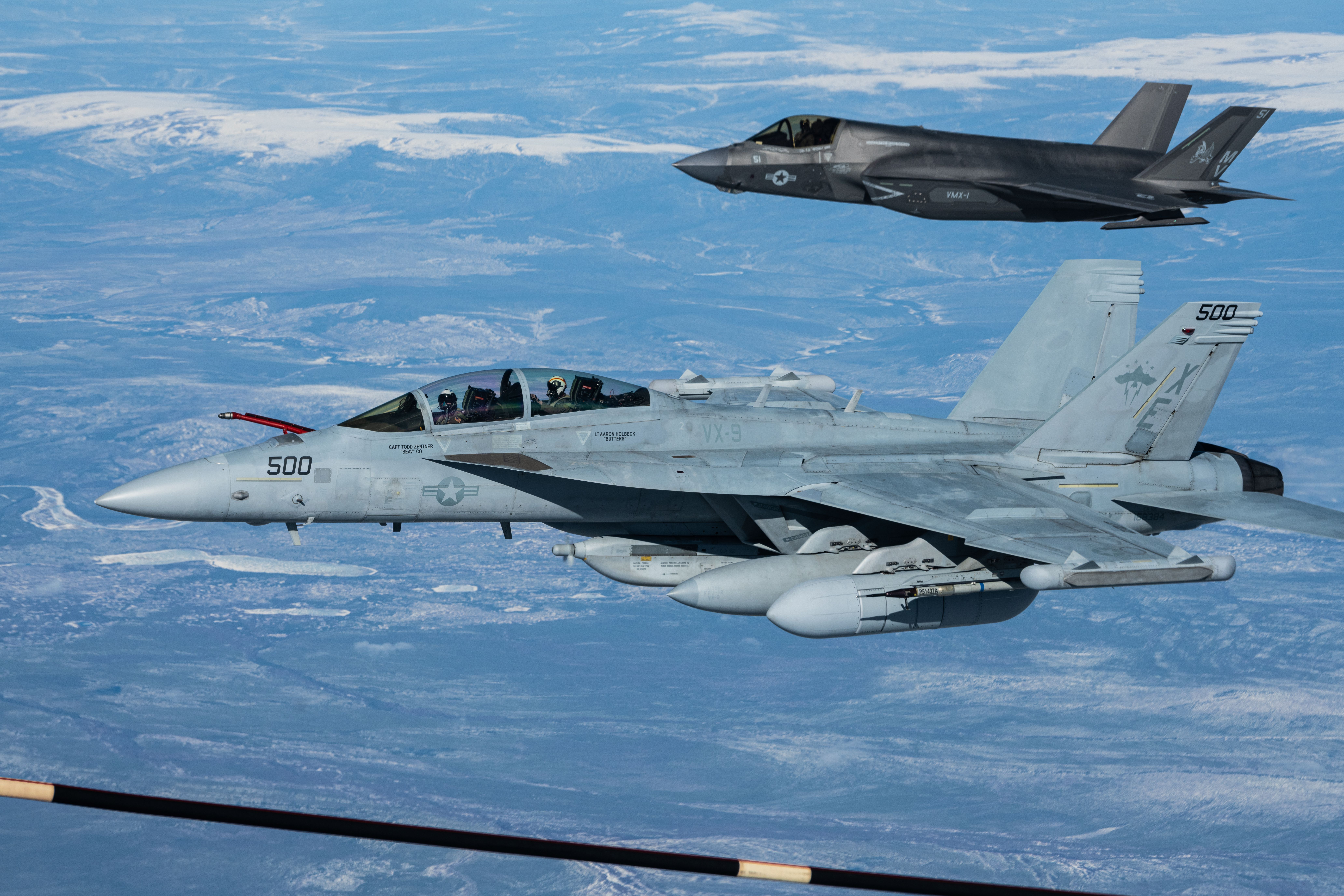 A U.S. Navy EA-18G “Growler” and a U.S. Marine Corps F-35B Lightning flying in formation.