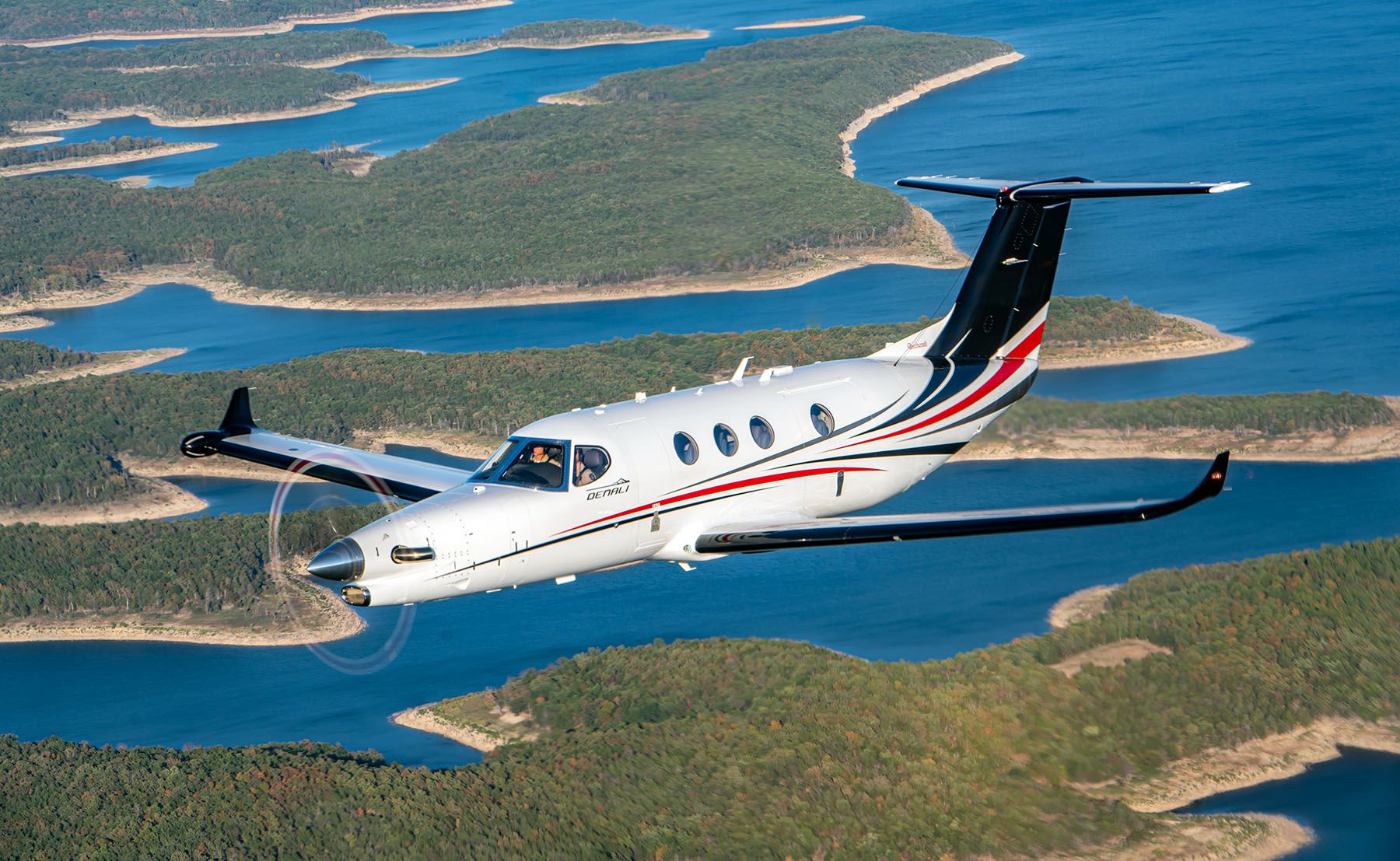 A Beechcraft Denali flying above coastal terrain.