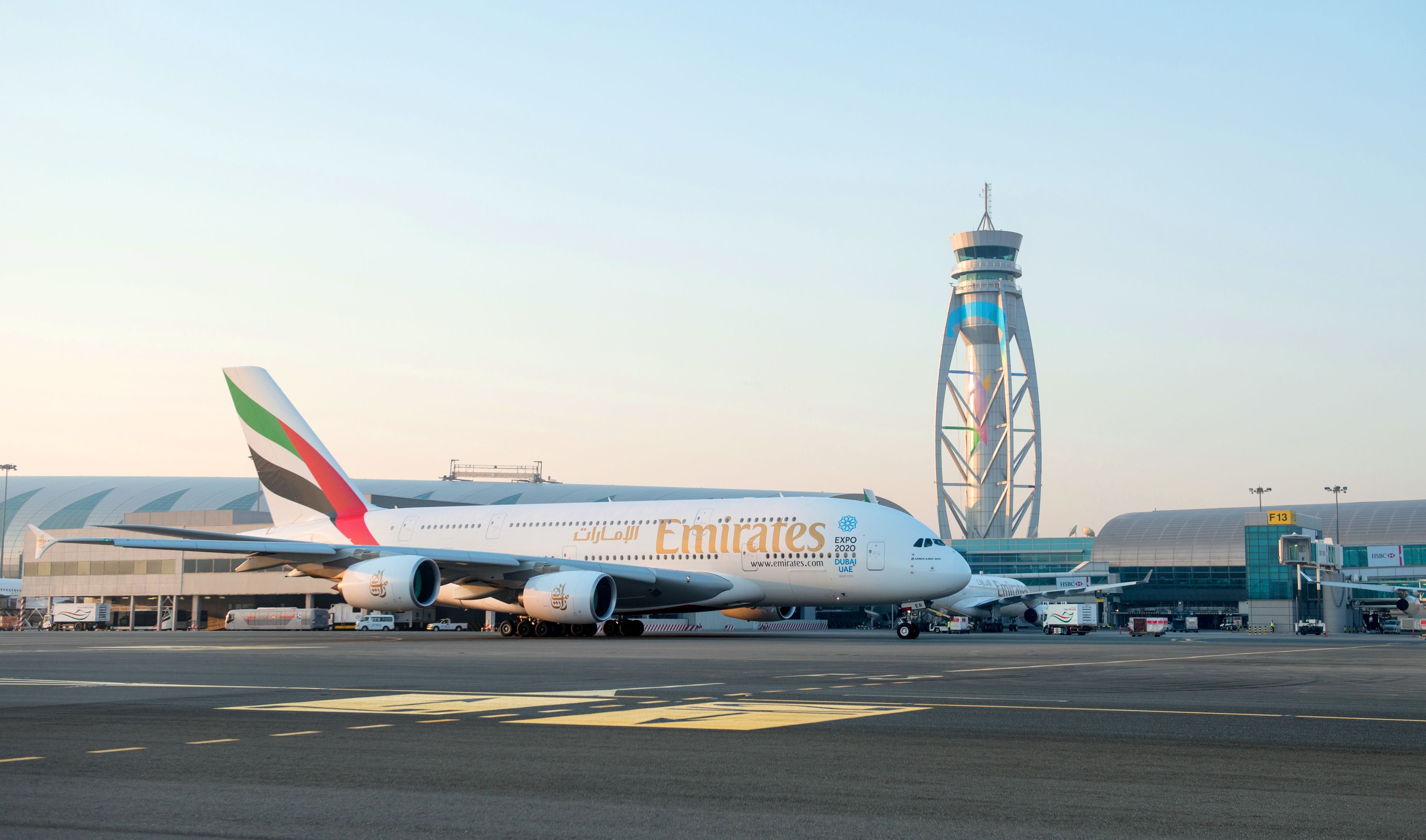 An Emirates Airbus A380 on the apron in front of the Dubai International Airport ATC tower.
