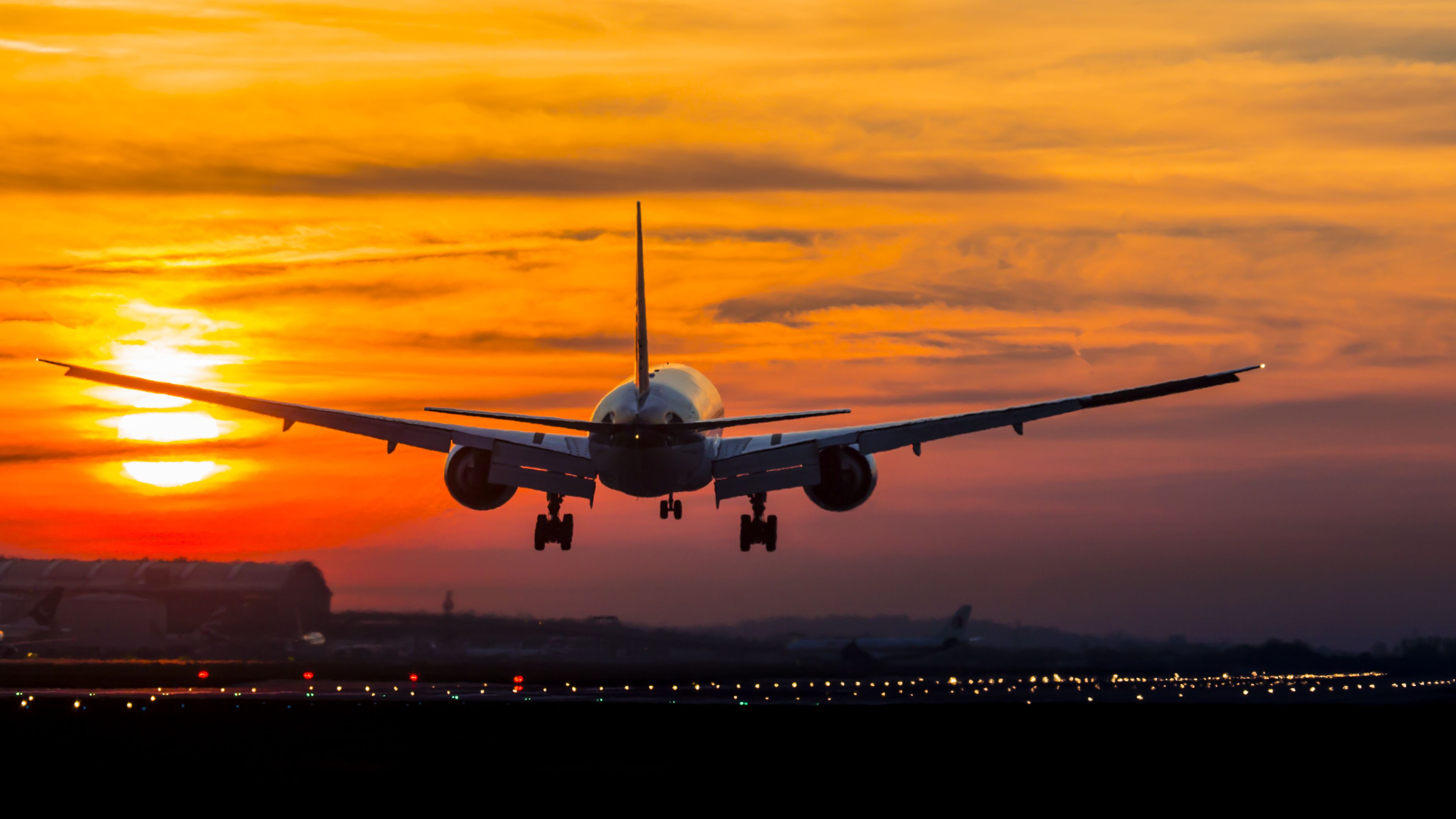 An aircraft landing at sunset.