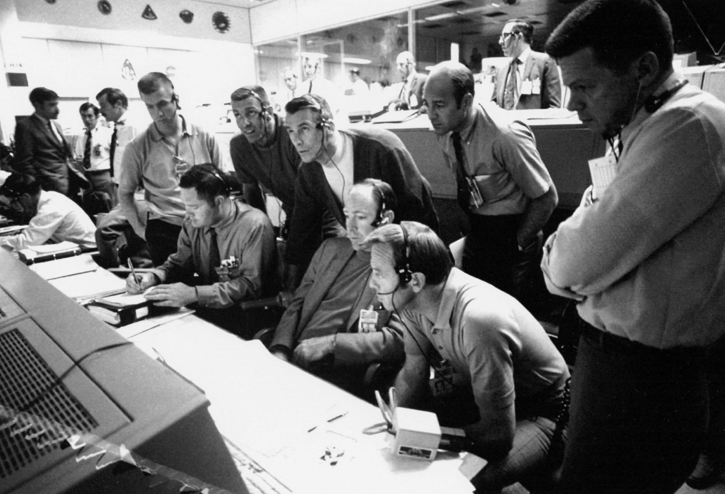 A black and white photo of NASA's Mission Control room filled with people.