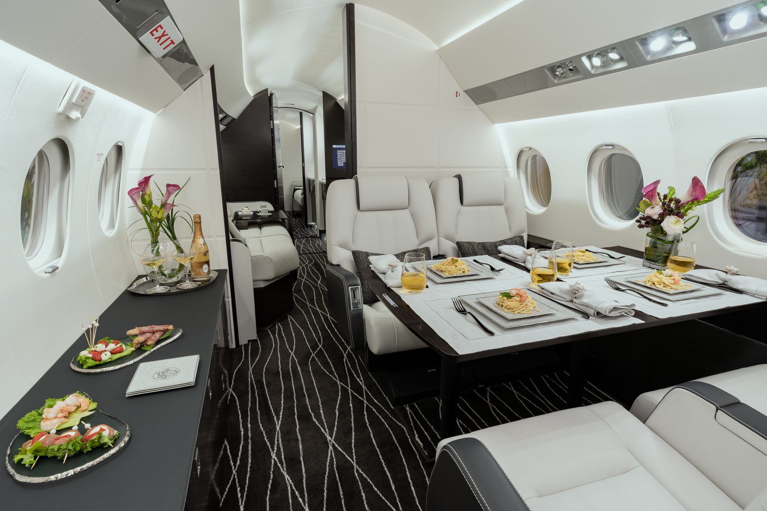 Inside the dining area of a private jet, already set up for dinner.