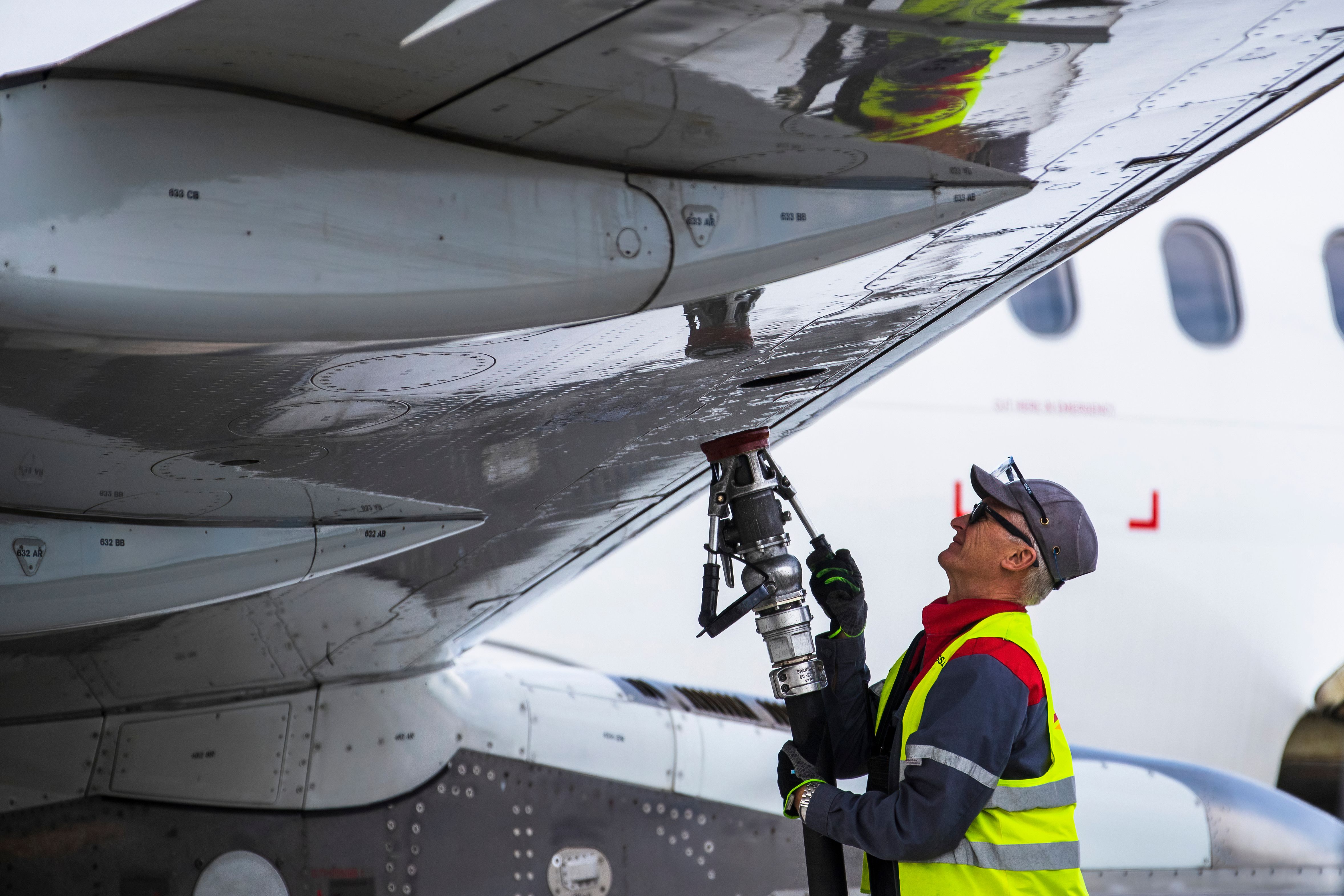 A worker fueling an aircraft at the airport.