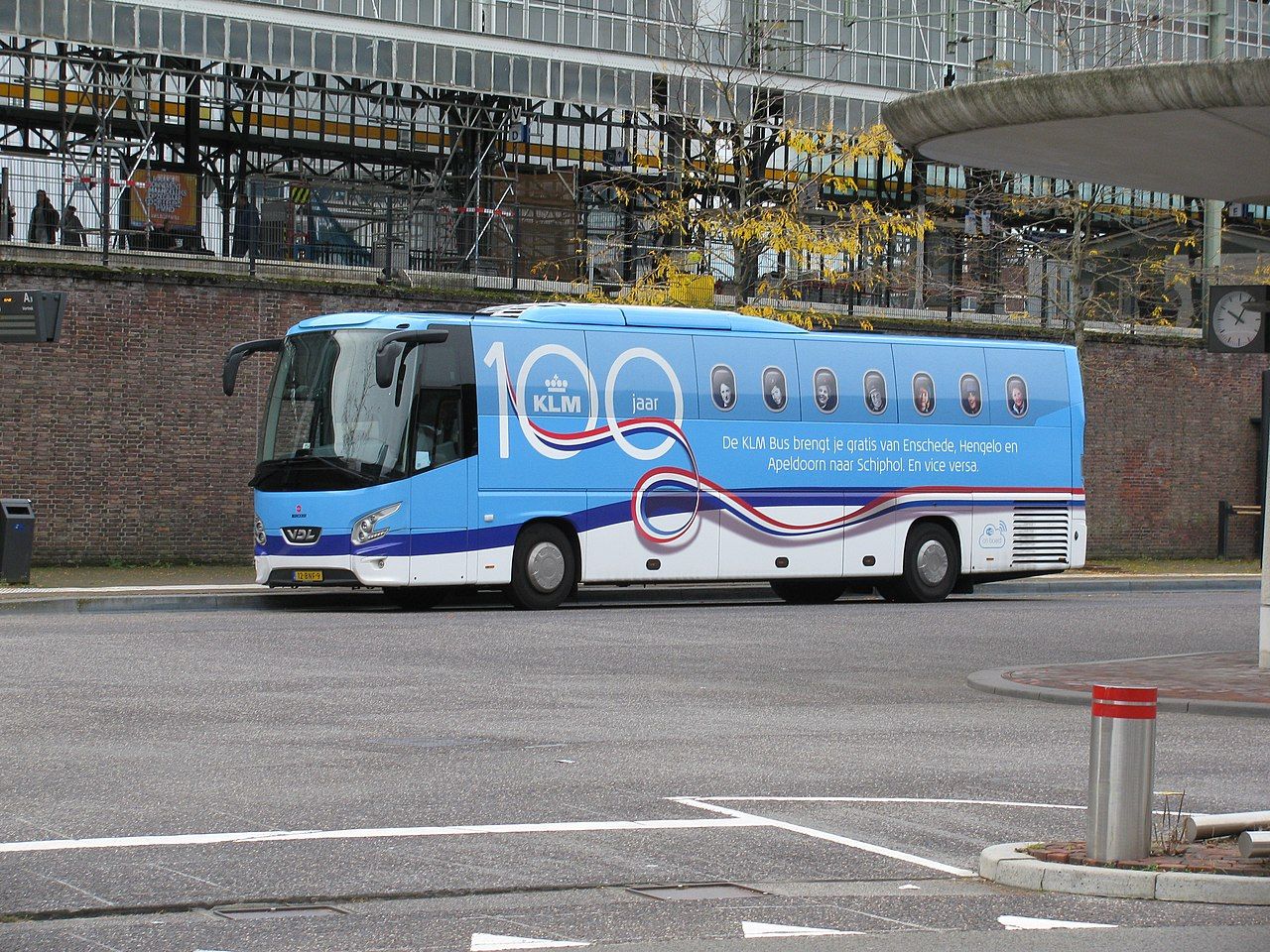 A KLM Bus driving on the street.