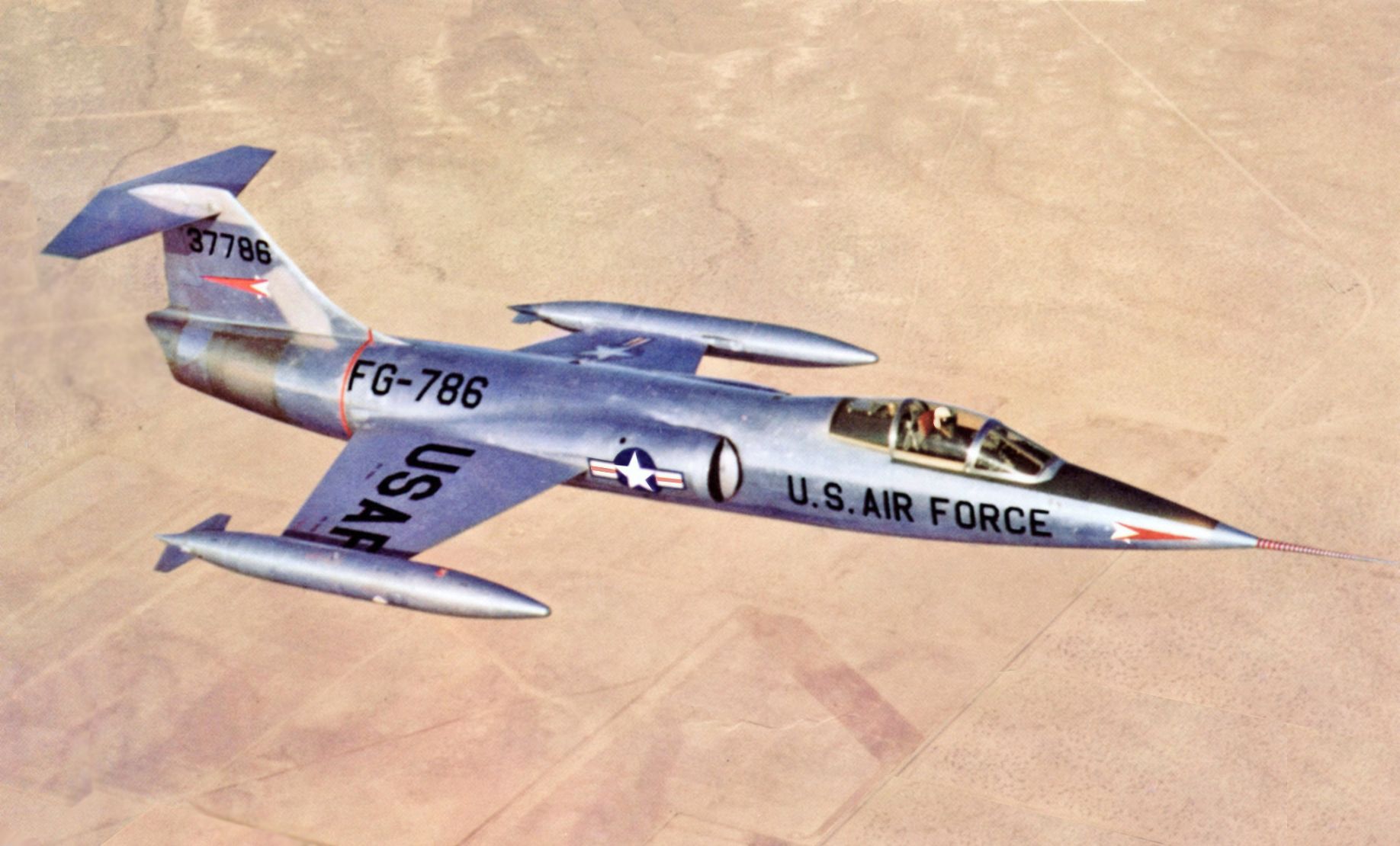 A Lockheed XF-104 flying over a desert.