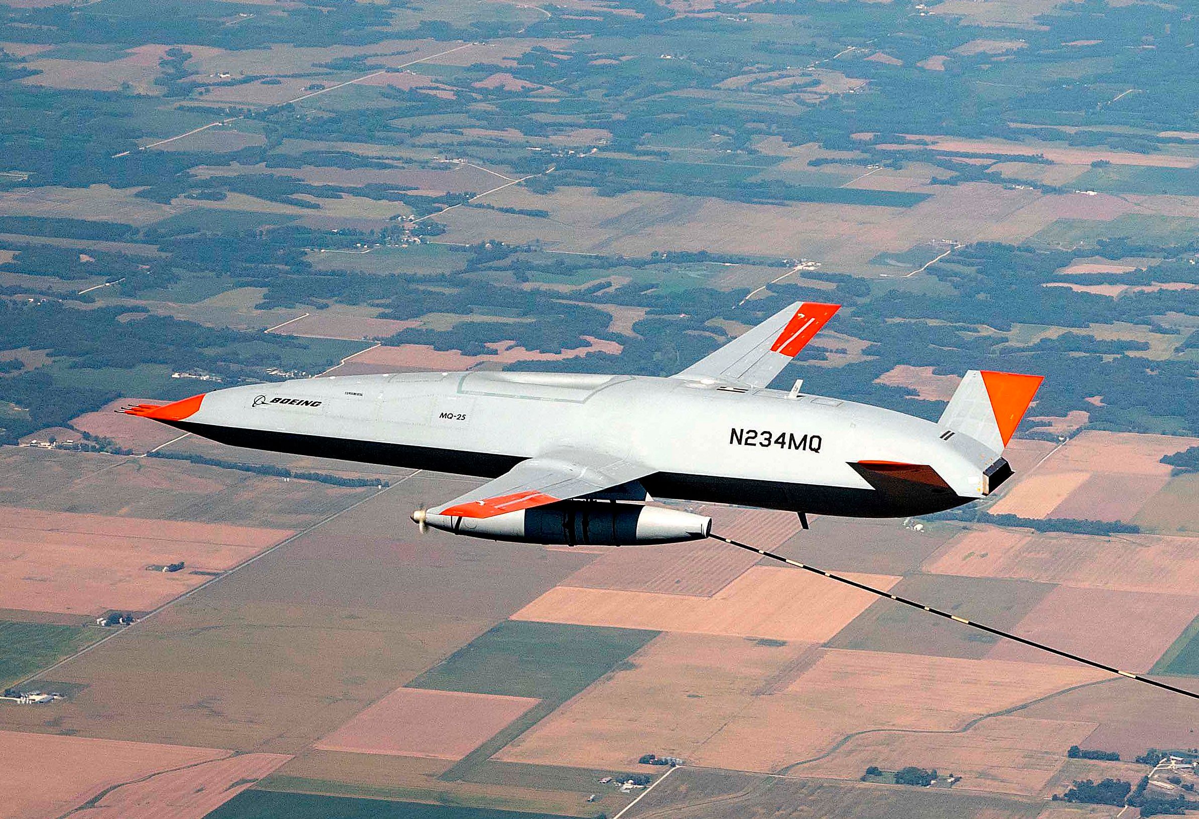 A Boeing MQ-25 Aerial Refueling Drone flying above farmland.