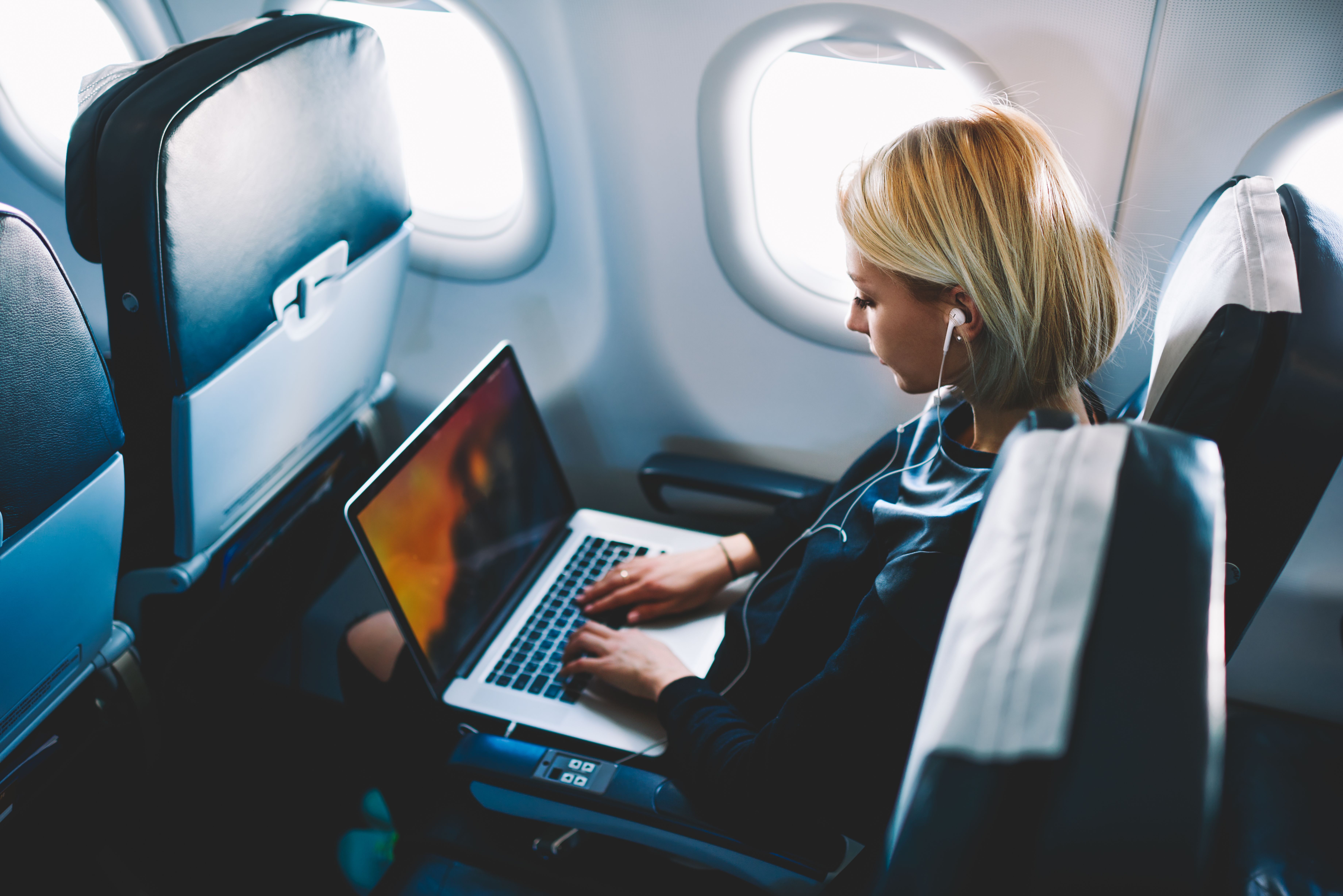 A passenger uses a laptop onboard an aircraft.