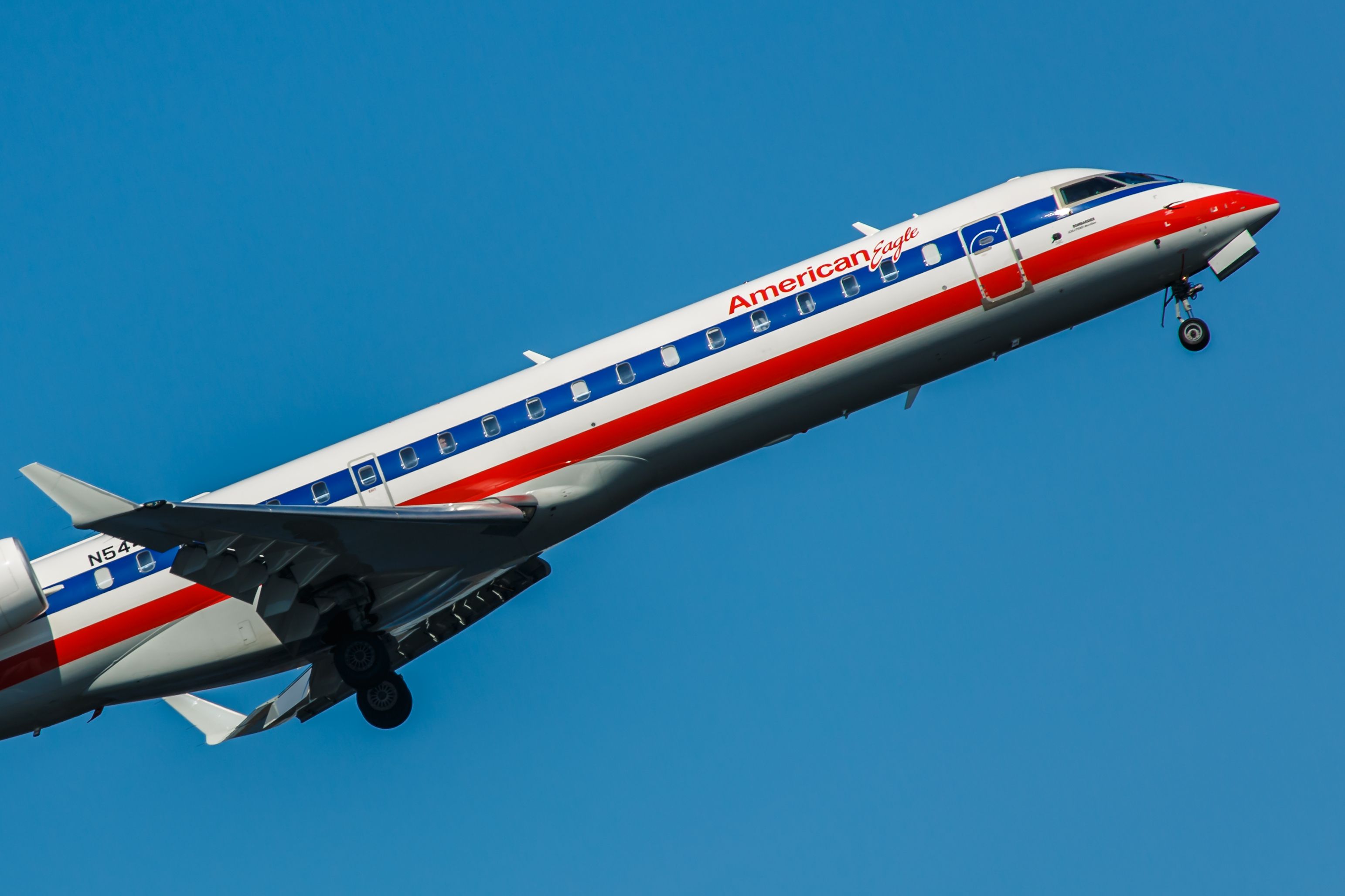 An American Eagle CRJ-700 flying in the sky.