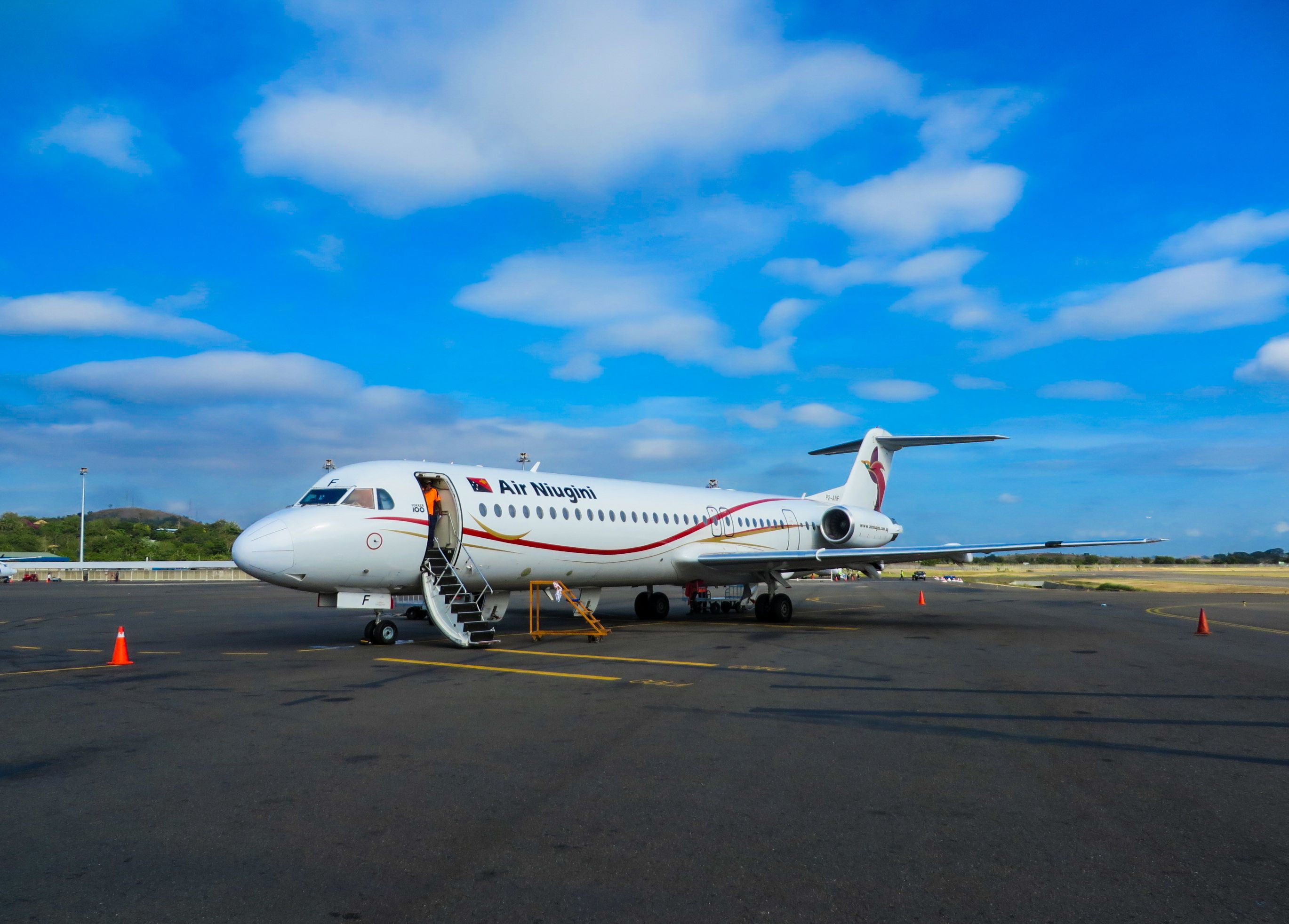 An Air Niugini Fokker 100 parked at an airport.