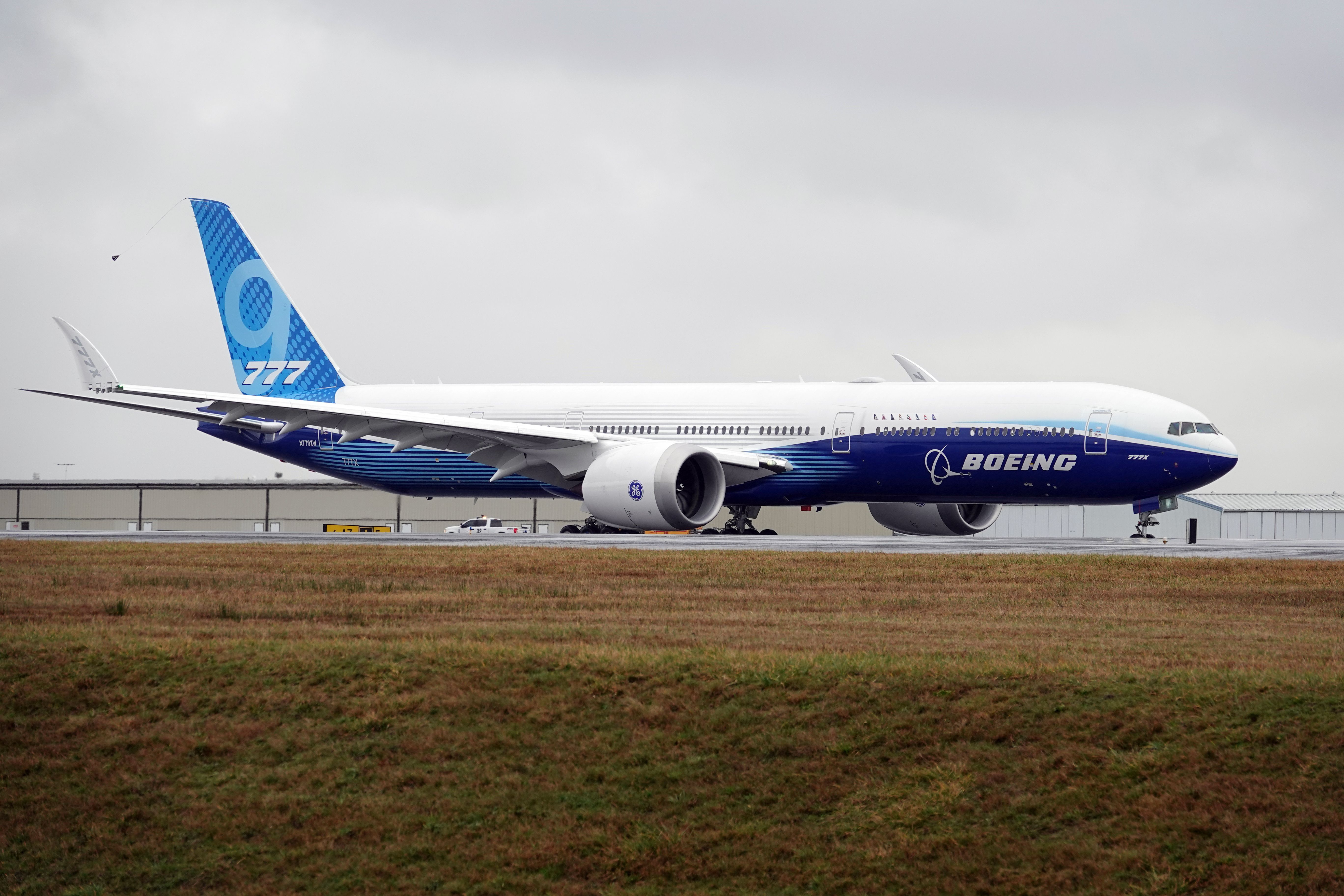 A Boeing 777X taxiing at an airfield.