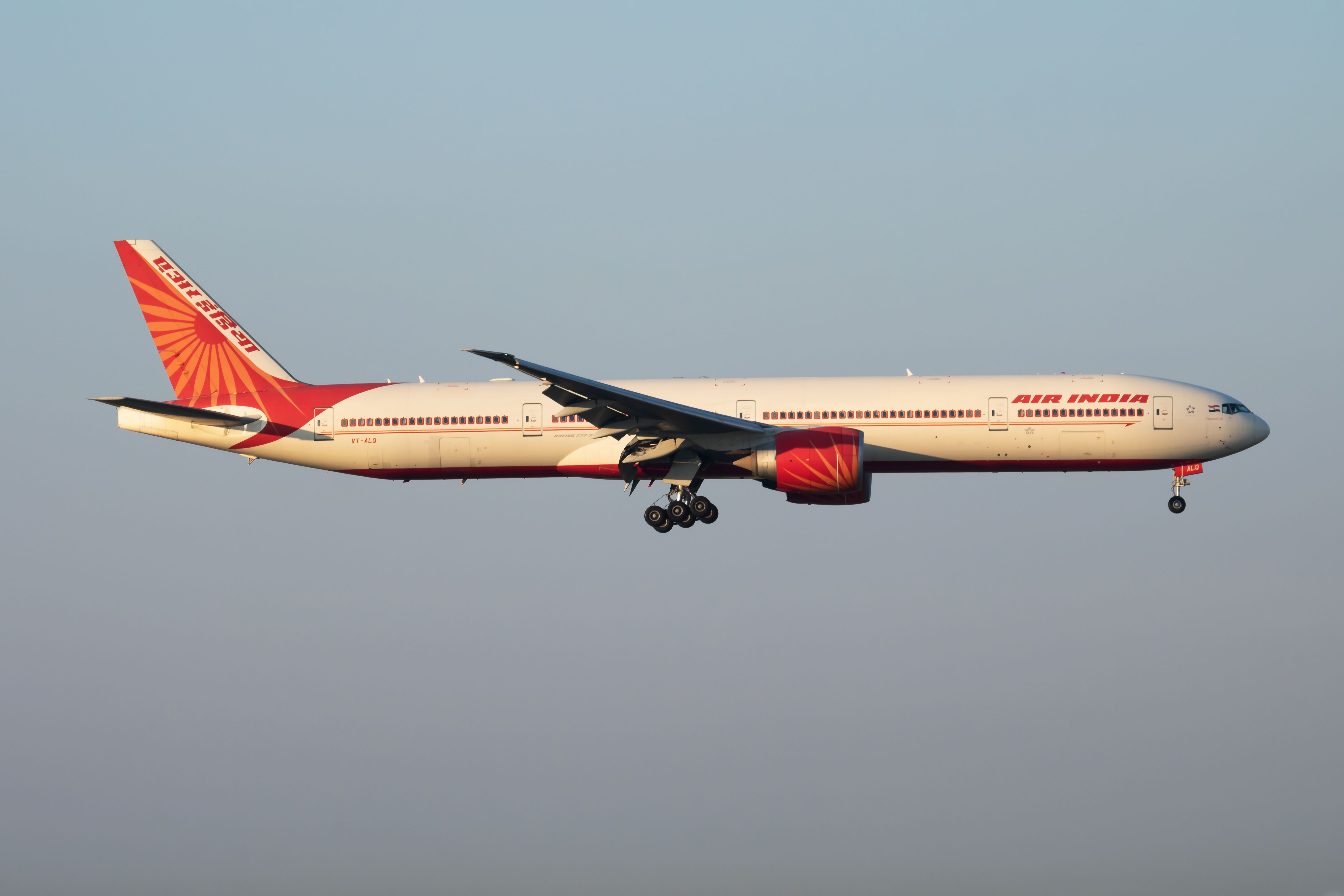 An Air India Boeing 777-300ER flying in the sky.